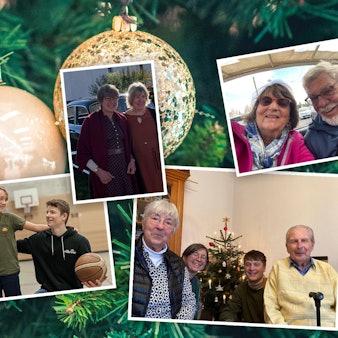 Vor einem Weihnachtsbaum hängen Bilder von geliebten Menschen.