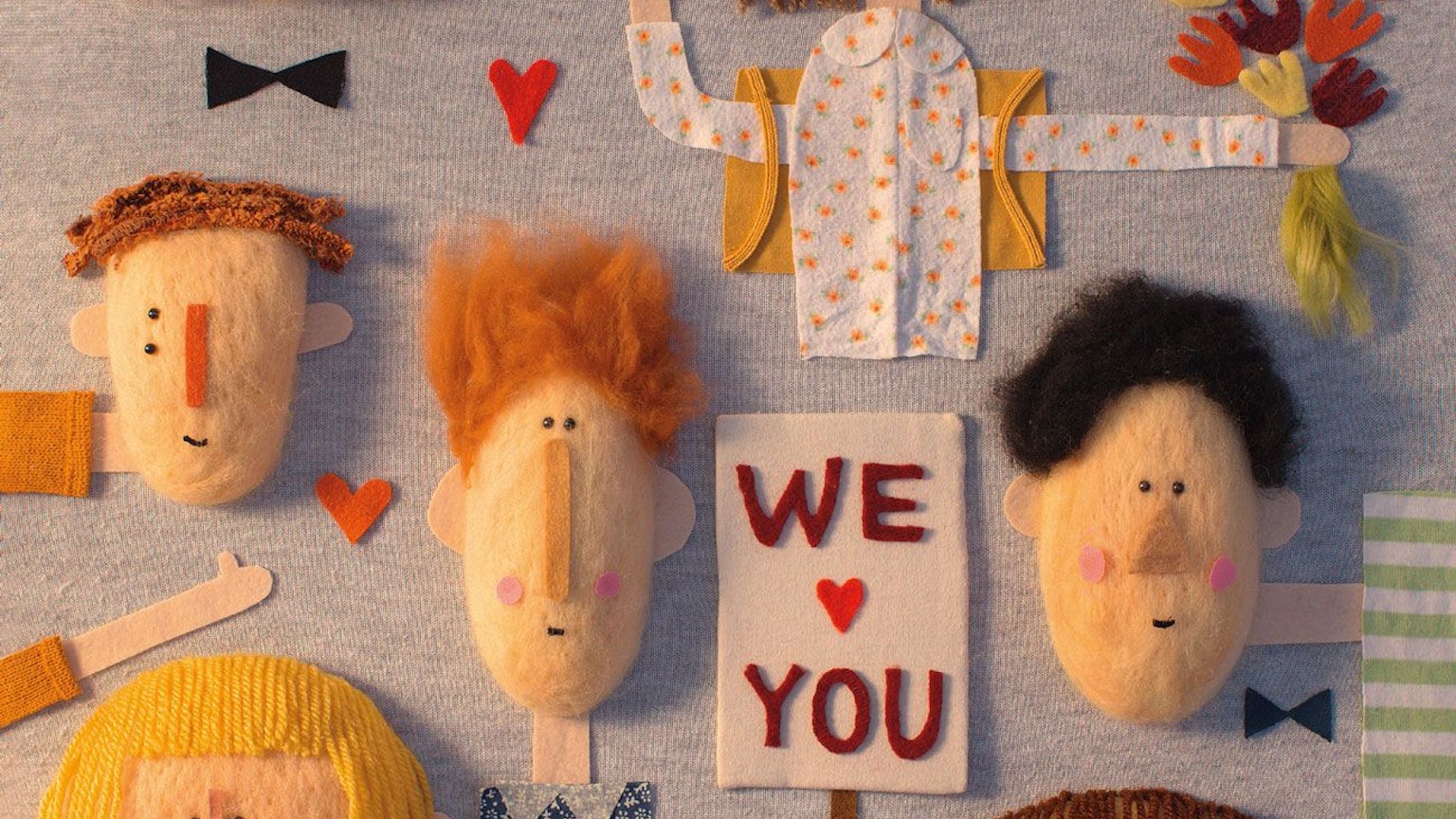 Viele Gesichter und ein Schild mit der Aufschrift We love You, Collage aus Stoff