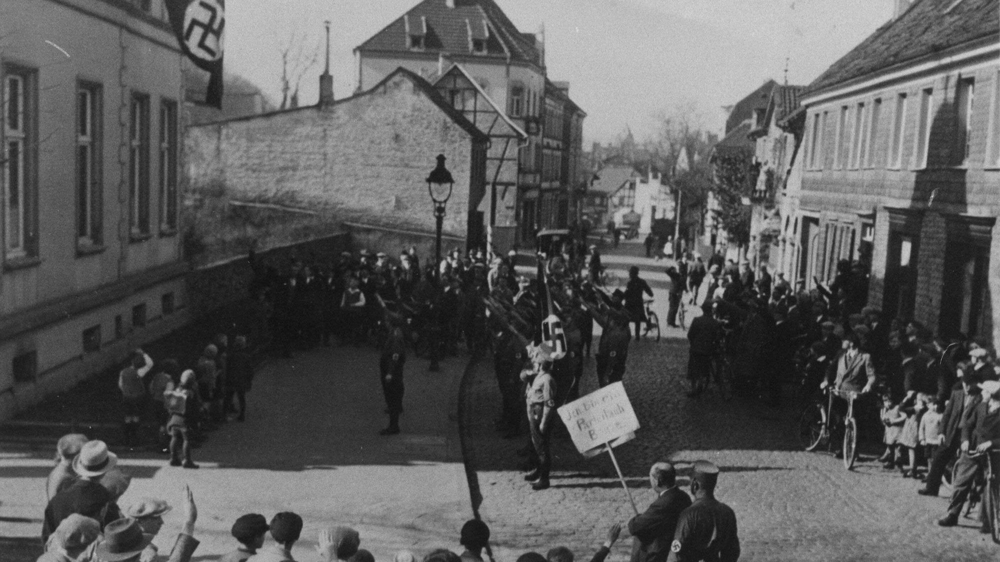 Schwarz-Weiß-Foto von 1933: Arbeitsamtsdirektor Peter Walterscheidt wird in der Bergisch Gladbacher Hauptstraße von SA und NS öffentlich verhöhnt.