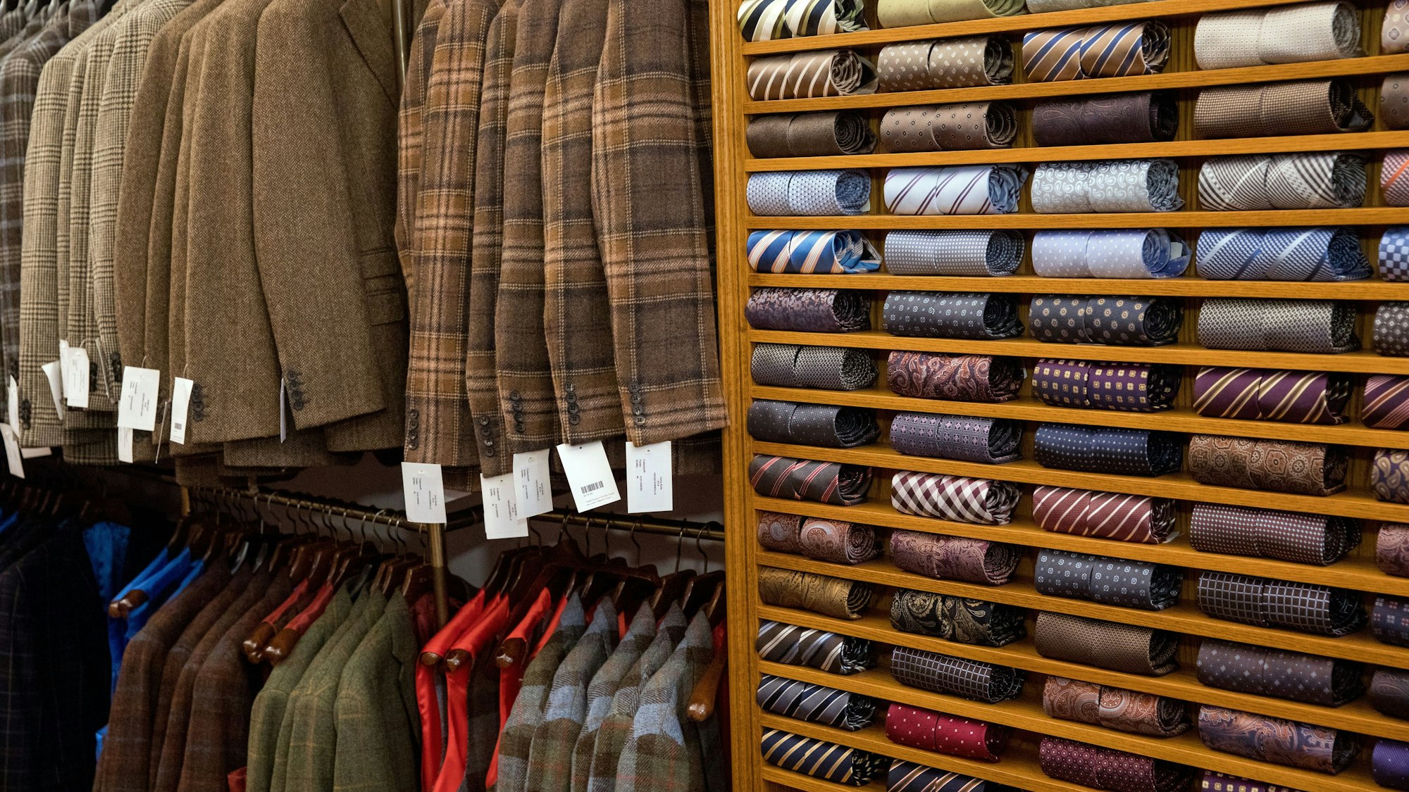 Tweed-Jackets in verschiedenen Designs und ein Regal voller Krawatten im Laden in der Friesenstraße.