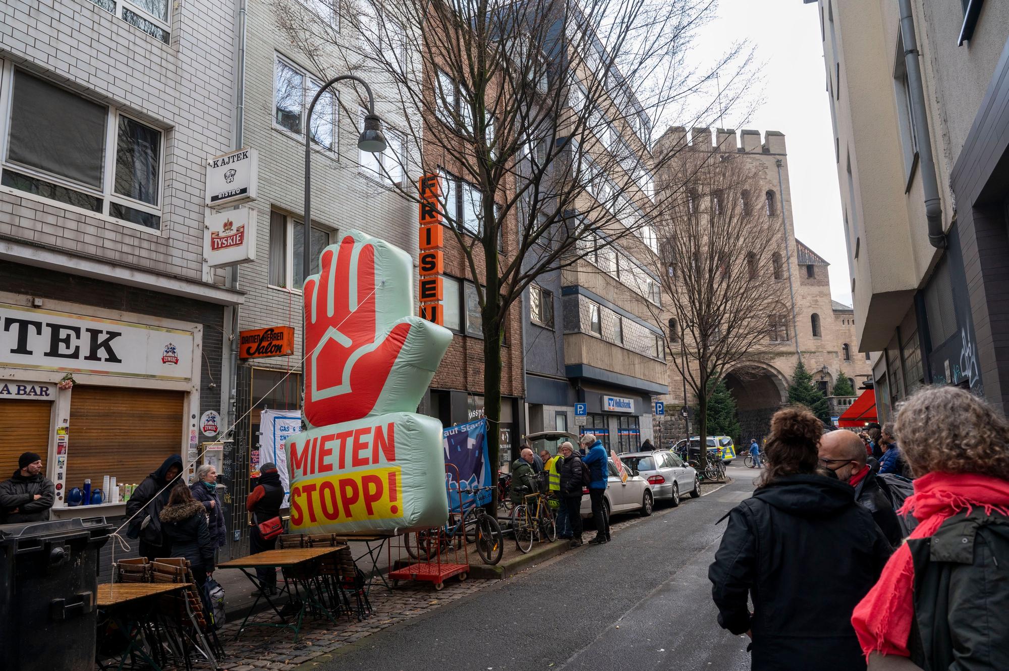 Vor dem Geisterhaus Im Ferkulum 8 findet eine Unterstützungs-Kundgebung statt. Die Demonstrierenden haben eine aufgeblasene Hand aufgestellt.
