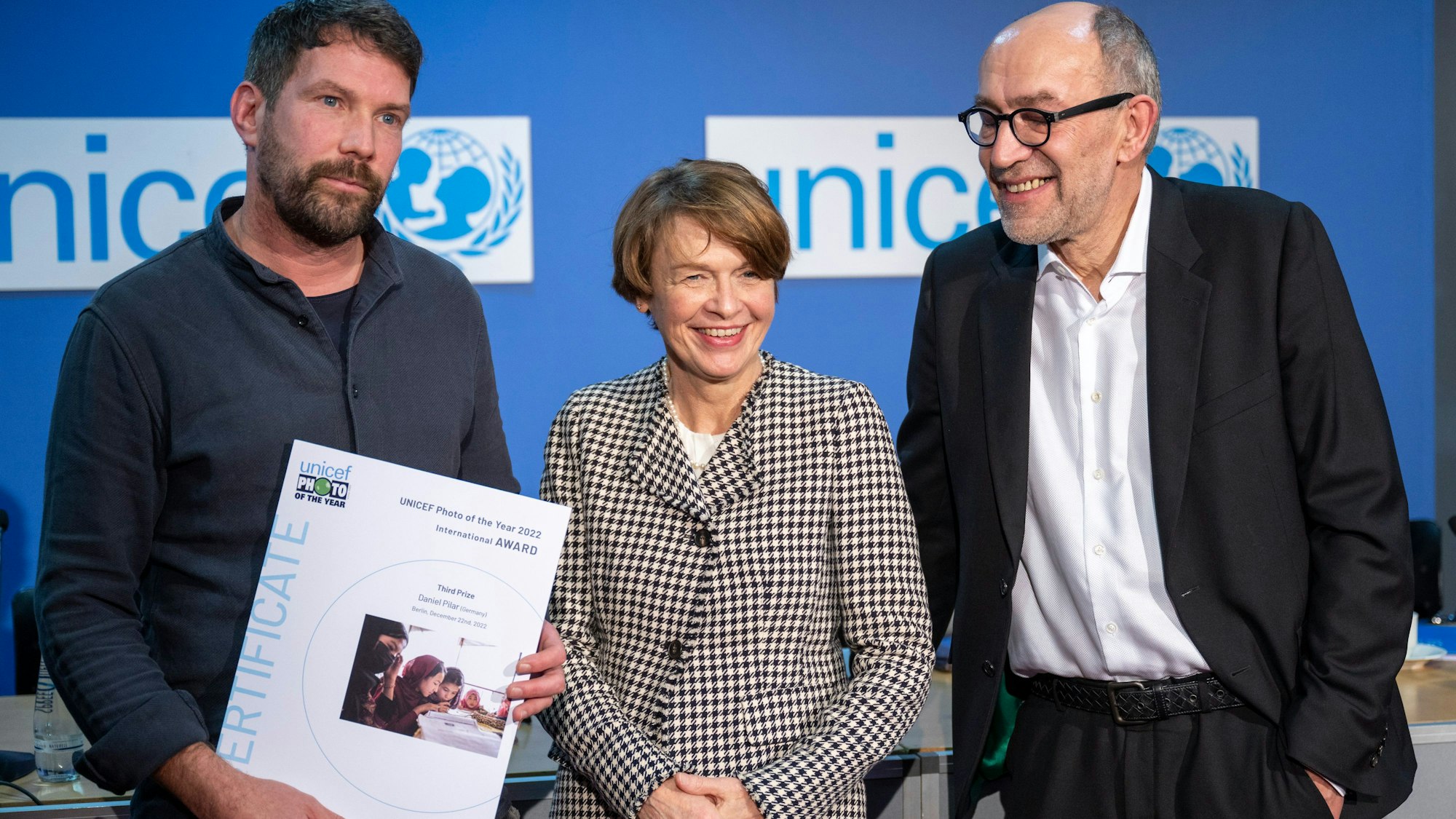 Daniel Pilar (l), bekommt den dritten Platz beim Unicef-Foto des Jahres 2022, und steht bei der Preisverleihung neben Elke Büdenbender (M), Unicef-Schirmherrin und Ehefrau von Bundespräsident Steinmeier und Peter-Matthias Gaede, Chefredakteur des Magazins GEO und ehrenamtliches Mitglied im UNICEF-Vorstand.