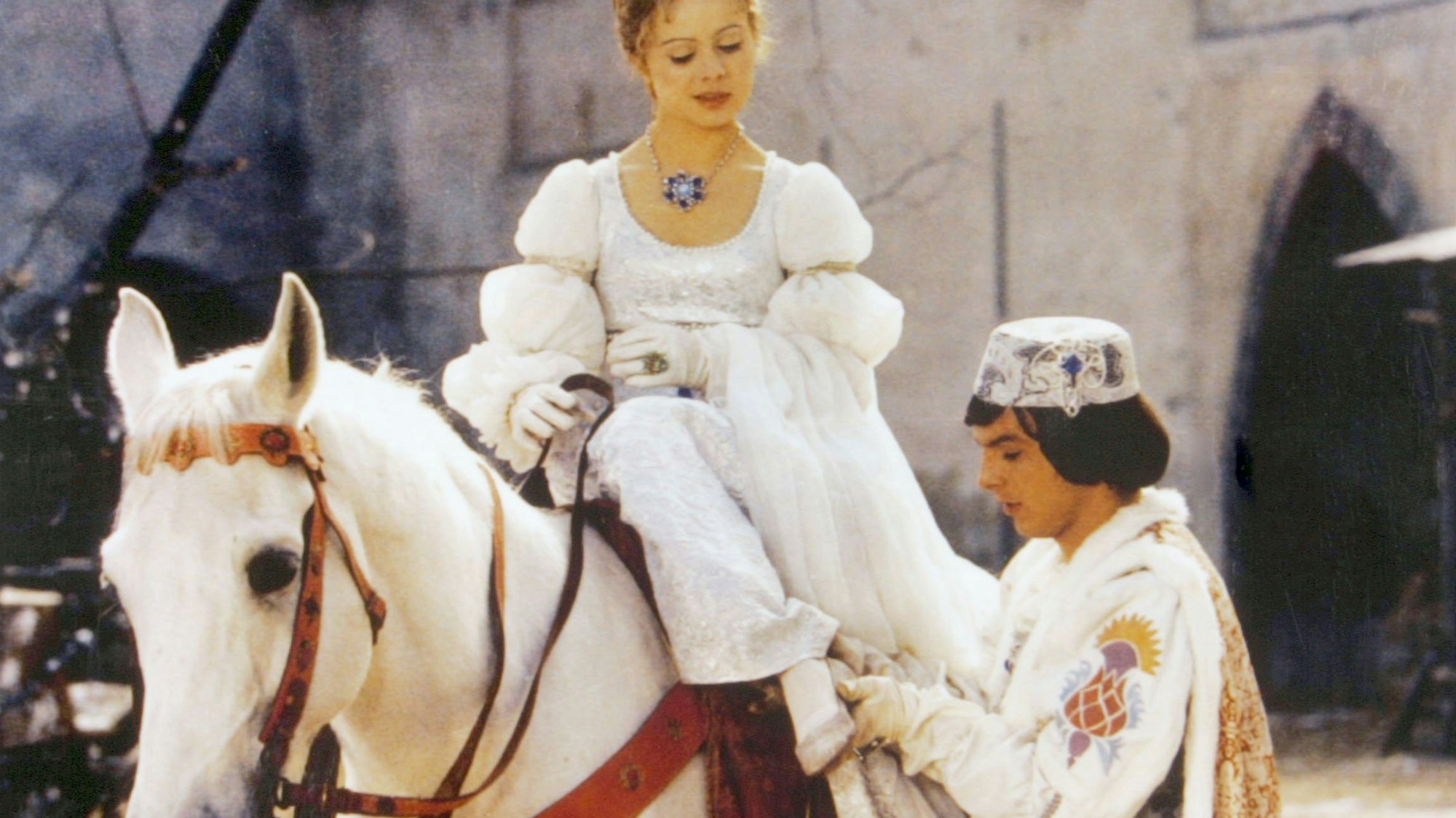Der Prinz (Pavel Trávnícek) passt Aschenbrödel (Libuse Safránková) den verlorenen Schuh an - eine Szene aus „Drei Haselnüsse für Aschenbrödel“.