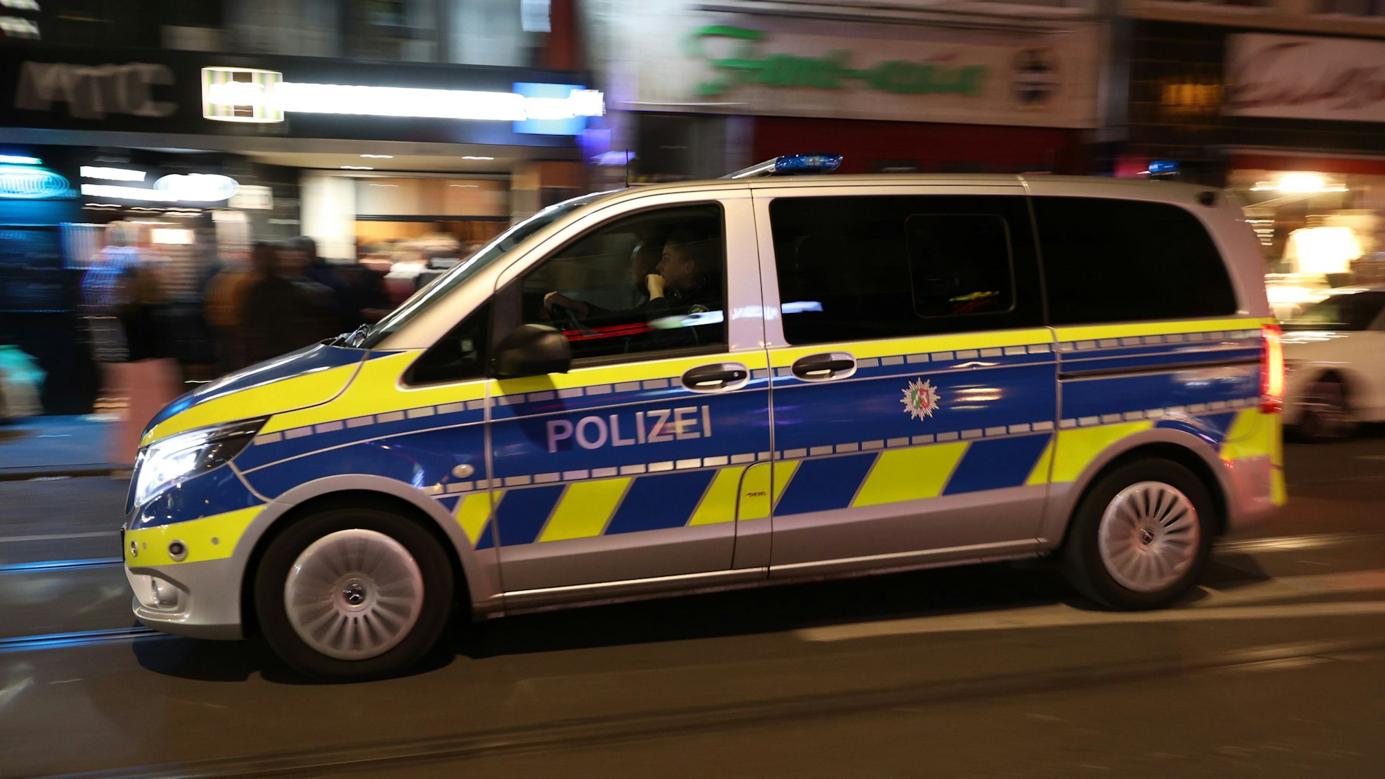 Das Foto zeigt einen Einsatzwagen der Polizei Köln bei Nacht.