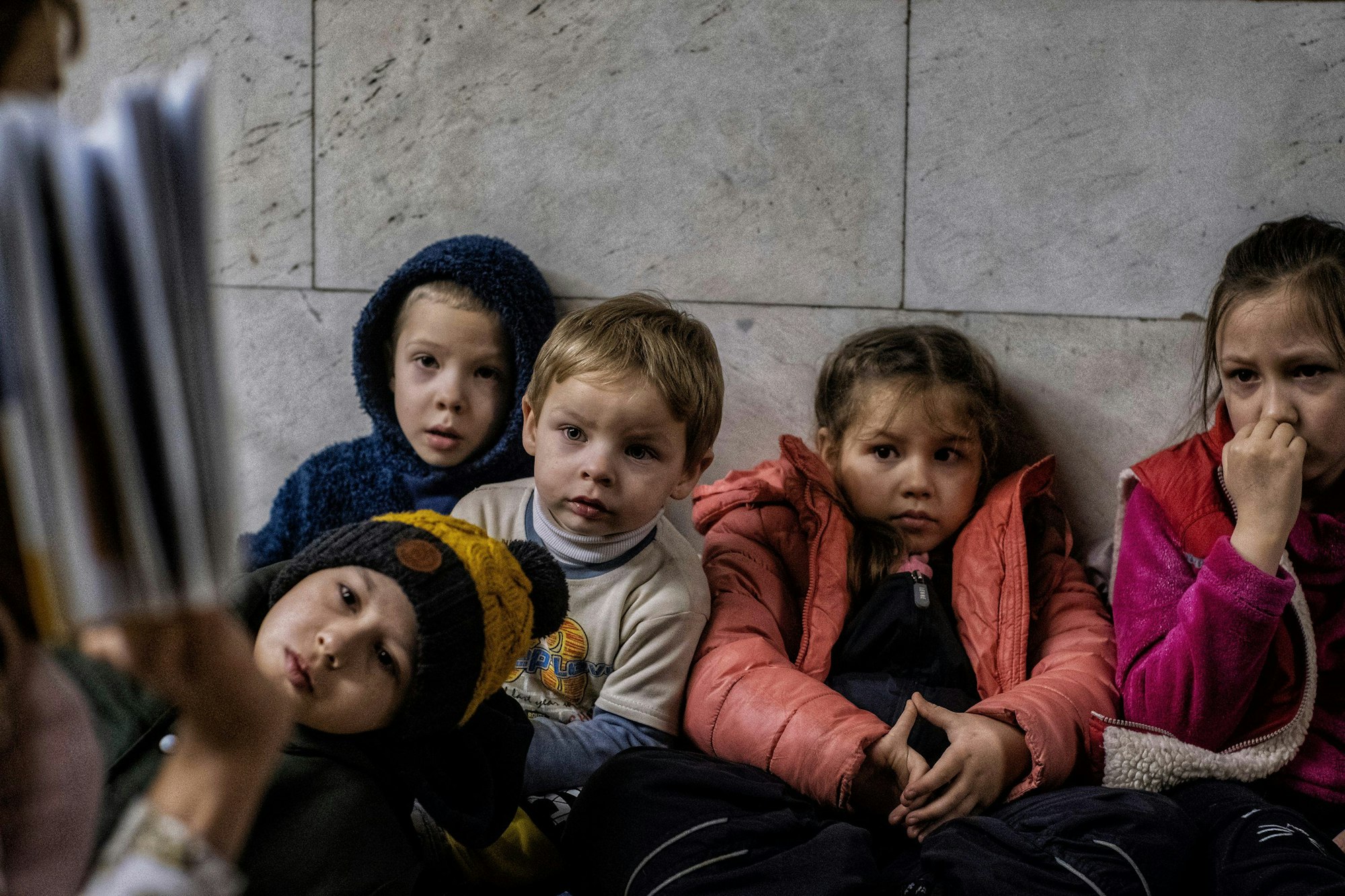 Ein Lehrer liest Kindern, die zum Schutz vor russischen Raketenangriffen in Kiew unterirdisch in den U-Bahn-Stationen leben, Geschichten vor, um ihre Ausbildung fortzusetzen.