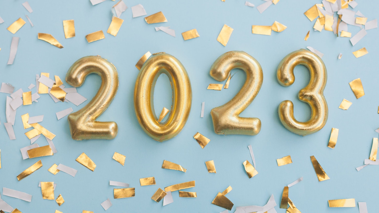 Der Schriftzug 2023 mit Konfetti auf blauem Hintergrund