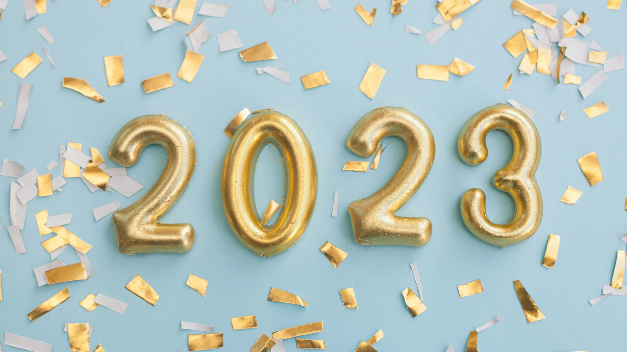 Der Schriftzug 2023 mit Konfetti auf blauem Hintergrund