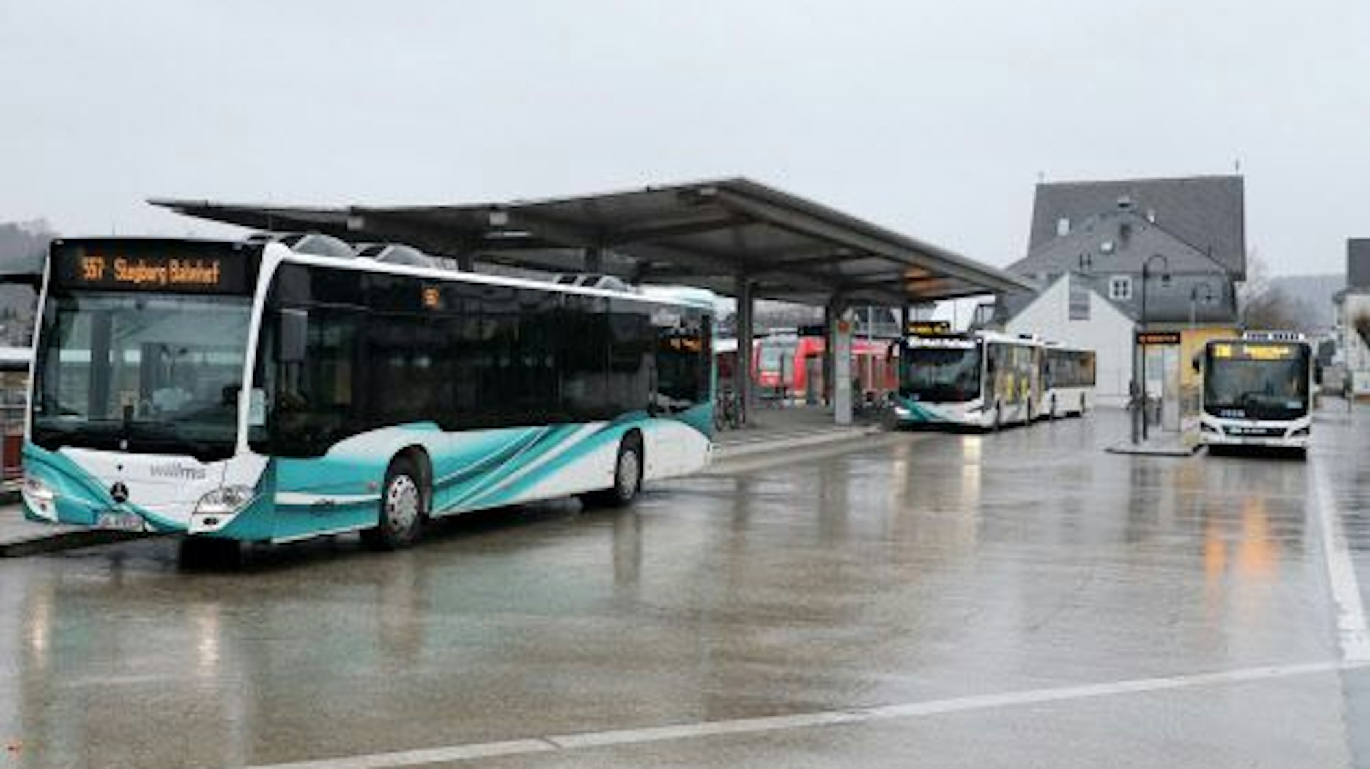 Drei Busse stehen an einem Busbahnhof