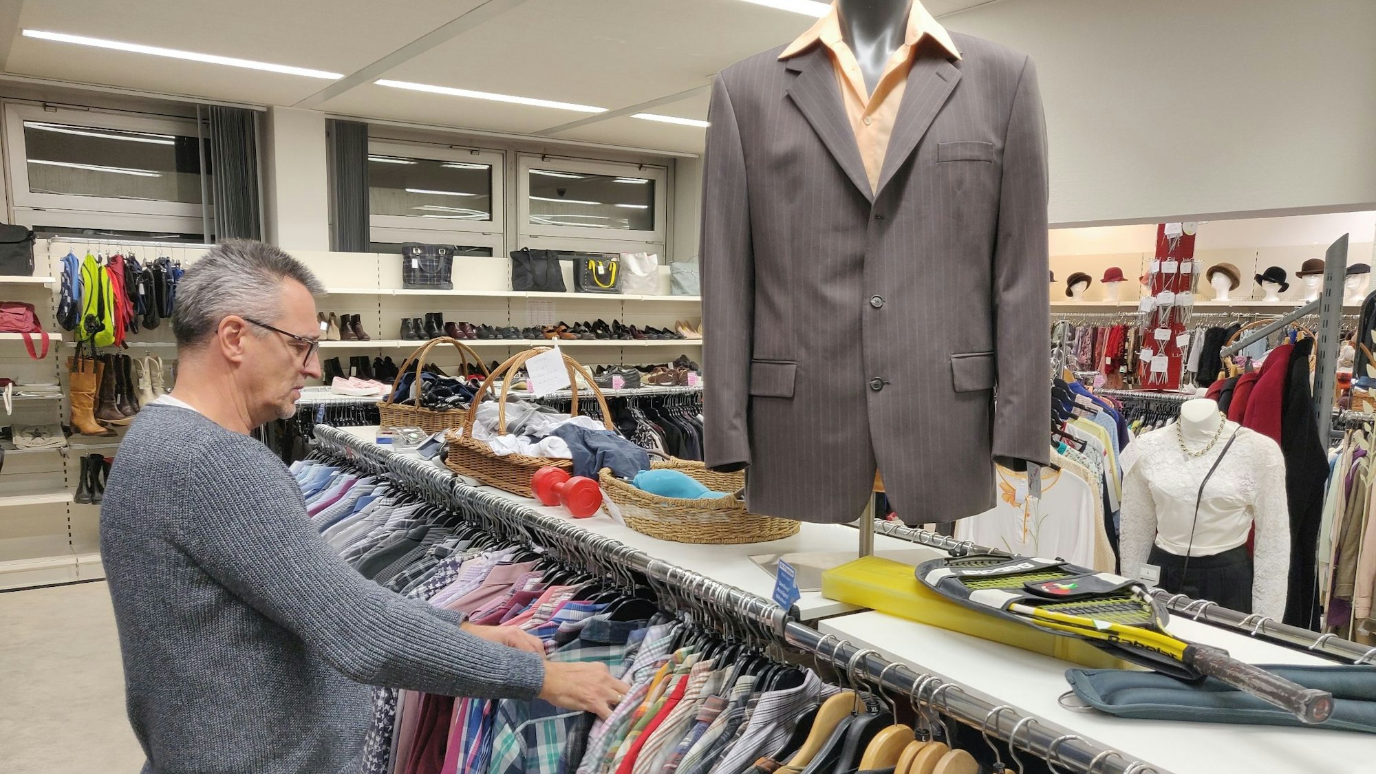 Thomas Rudnik vom Globolus-Team sortiert das Hemderegal in der Herrenkleidungsabteilung.