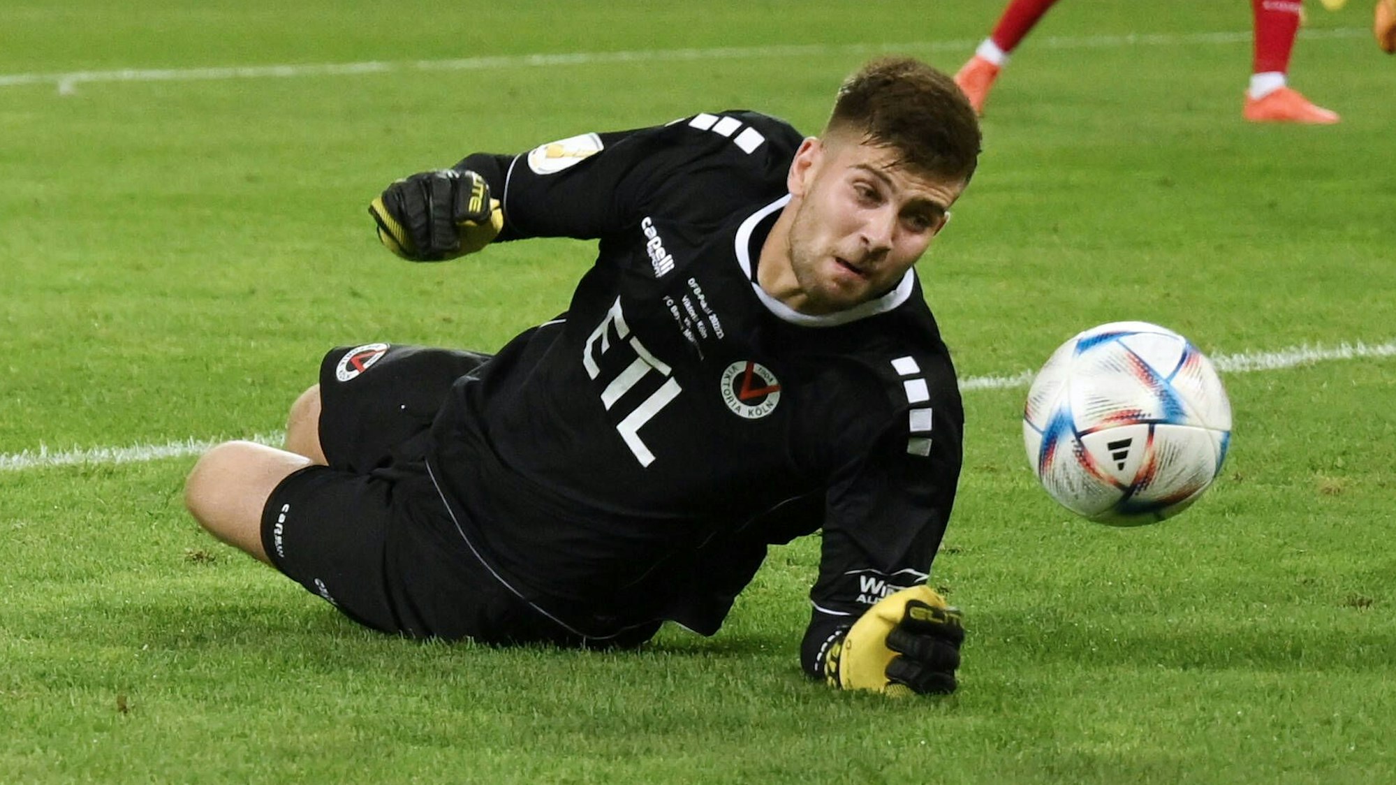 Ein Fußball-Torhüter pariert einen Ball.