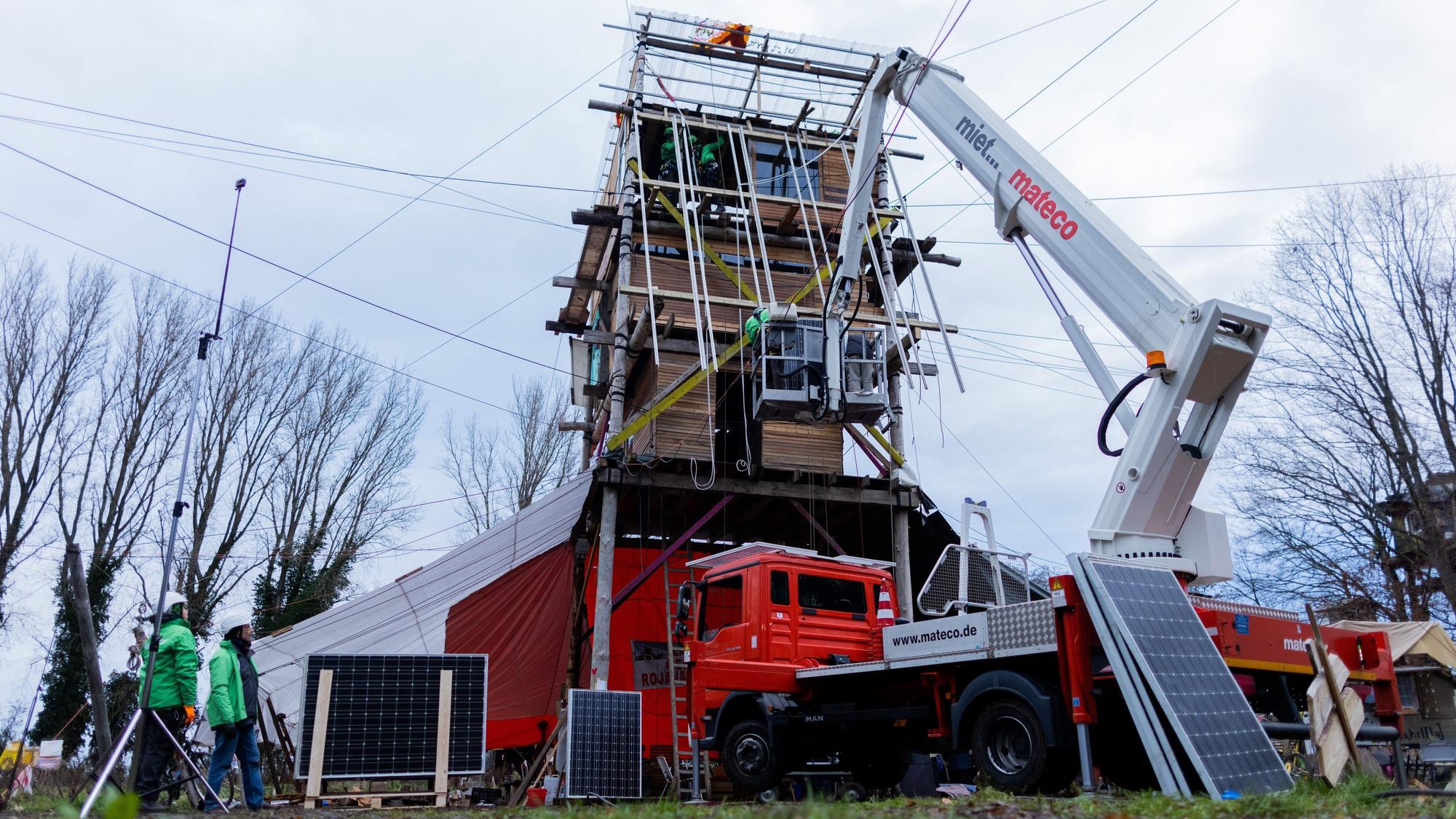 Photovoltaikanlagen werden von Greenpeace, ‚Lützerath Lebt‘ und ‚Alle Dörfer Bleiben‘ auf einem Holzturm installiert – dem Mittelpunkt und Versammlungsort des Protestcamps in Lützerath.