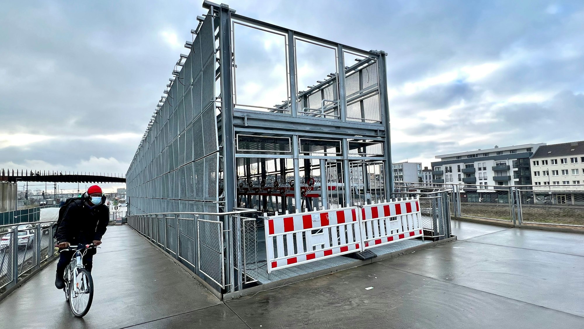 Ein Radfahrer müht sich die Rampe zum Fahrradparkhaus am Bahnhof Opladen hinauf, das immer noch nicht fertig ist.