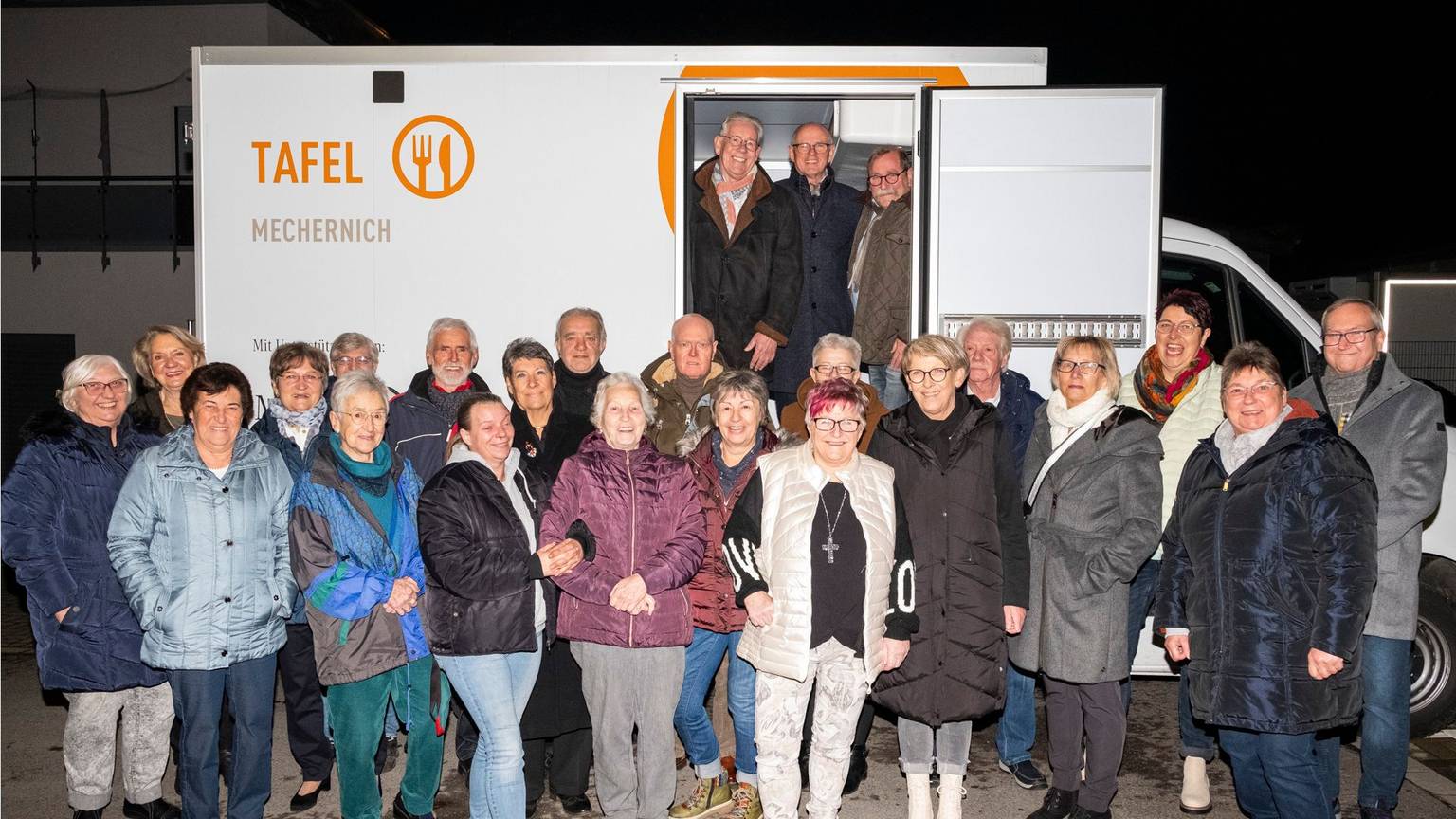 Das Tafel-Team steht vor dem neuen Kühlfahrzeug, das über Spenden finanziert wurde.