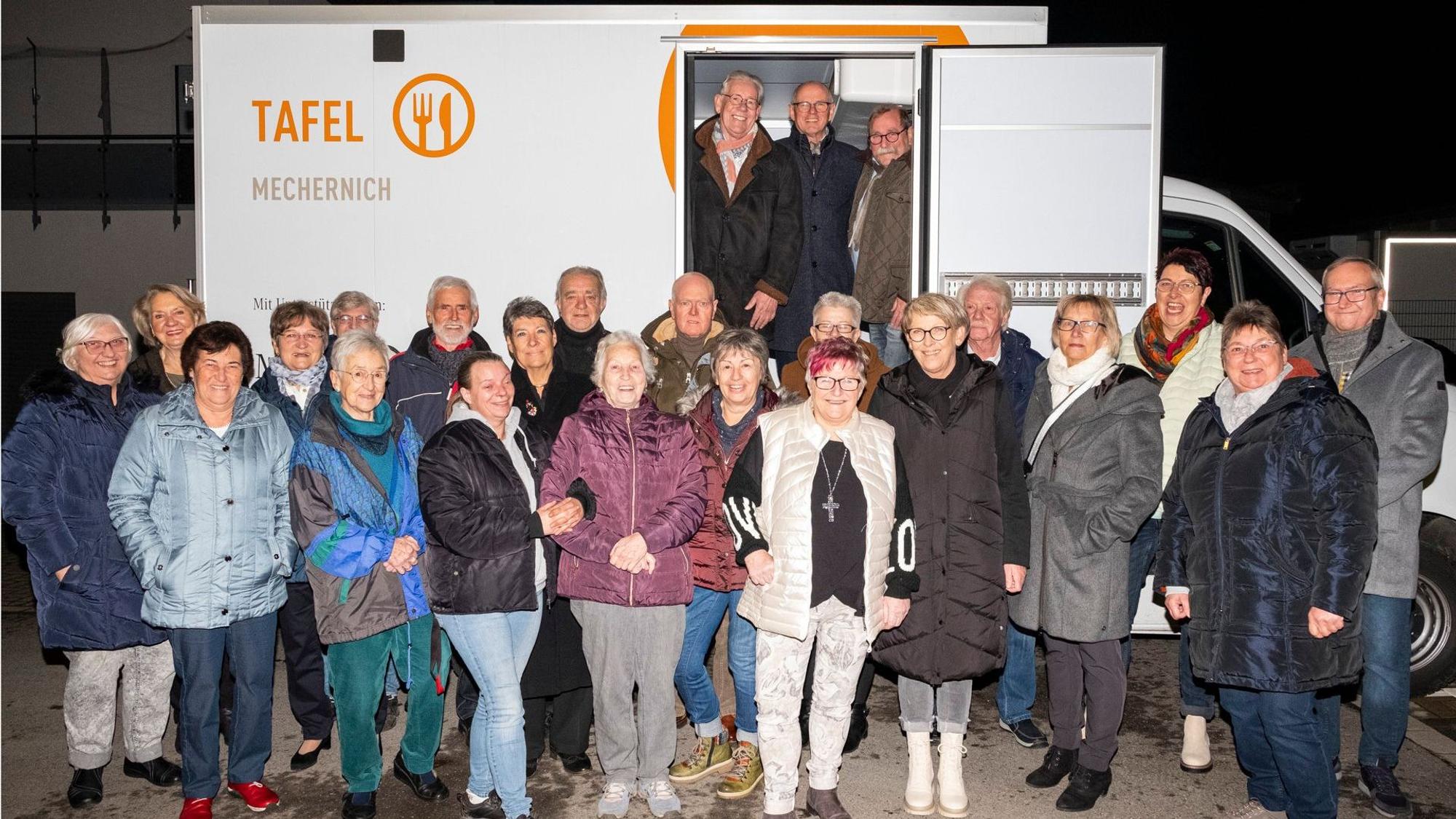 Das Tafel-Team steht vor dem neuen Kühlfahrzeug, das über Spenden finanziert wurde.
