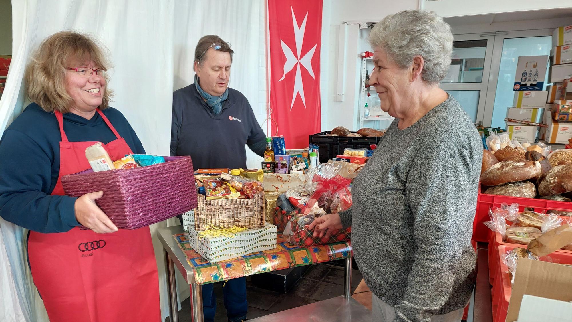 Malteser Tafel: Das Bild zeigt Petra Drehert und Gerhard Kunst, die die Tafel an der Steinstraße 6 leiten, mit einer Kundin.