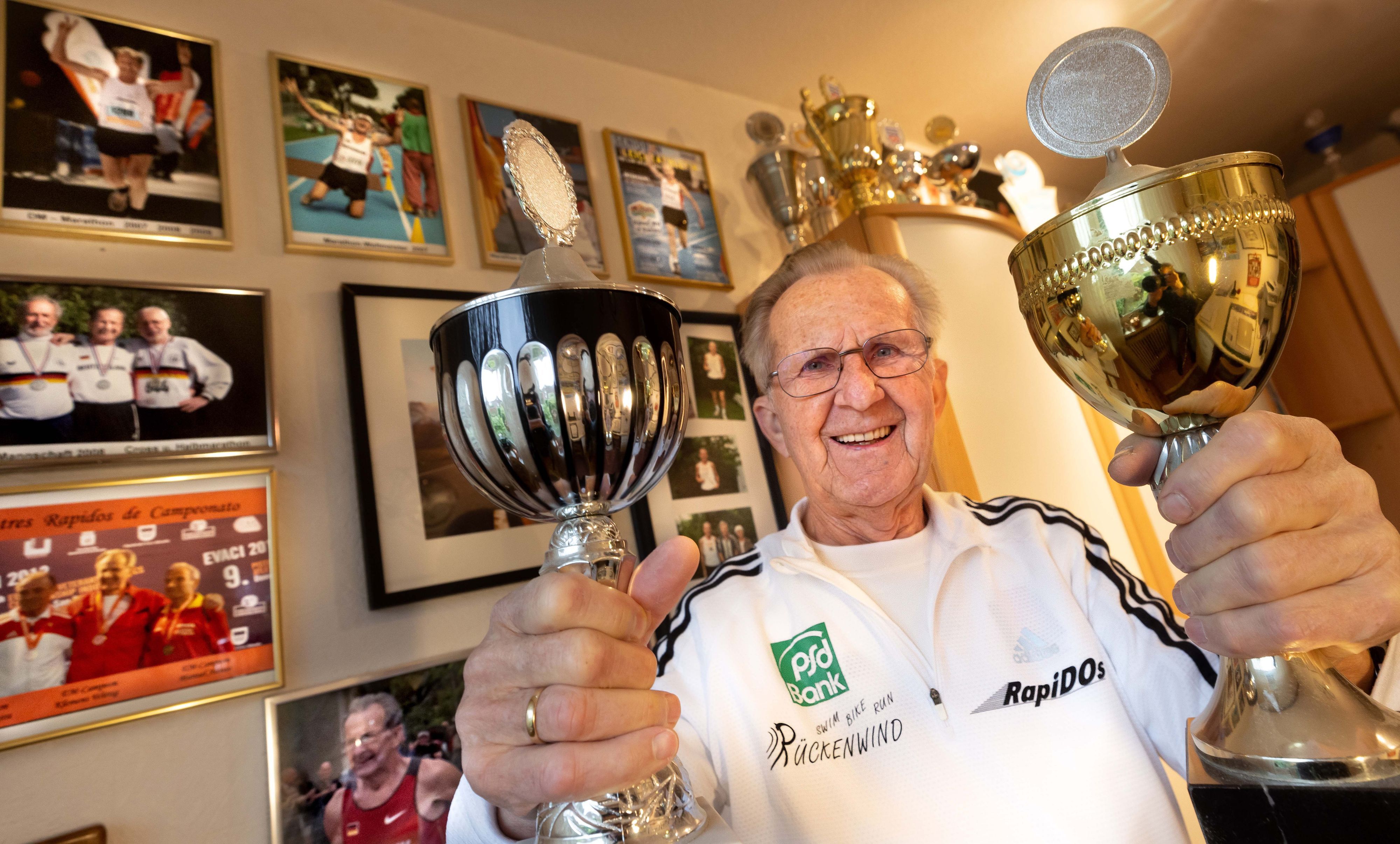 Klemens Wittig zeigt zwei seiner Pokale. Mit 85 Jahren nimmt der Dortmunder Langstreckenläufer noch immer regelmäßig an Wettkämpfen teil.