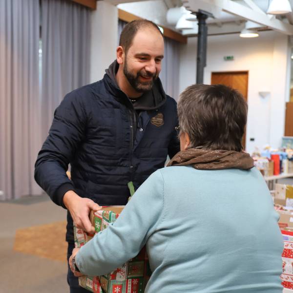 Ein Mann übergibt einen Karton mit Spenden.