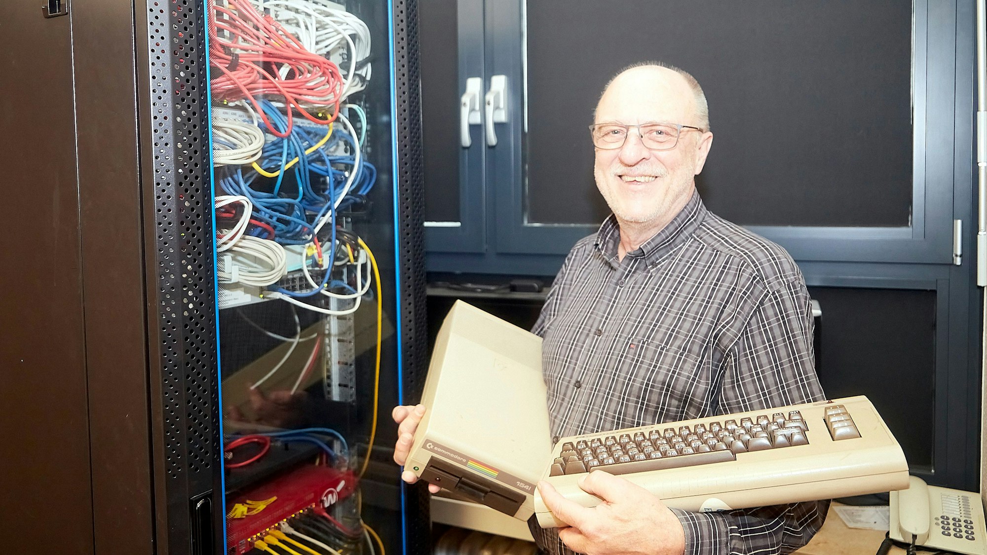 Hartmut Murk zeigt zwei Generationen PC-Technik: links der Schulserver des Clara-Fey, rechts ein Commodore C64 und ein Diskettenlaufwerk