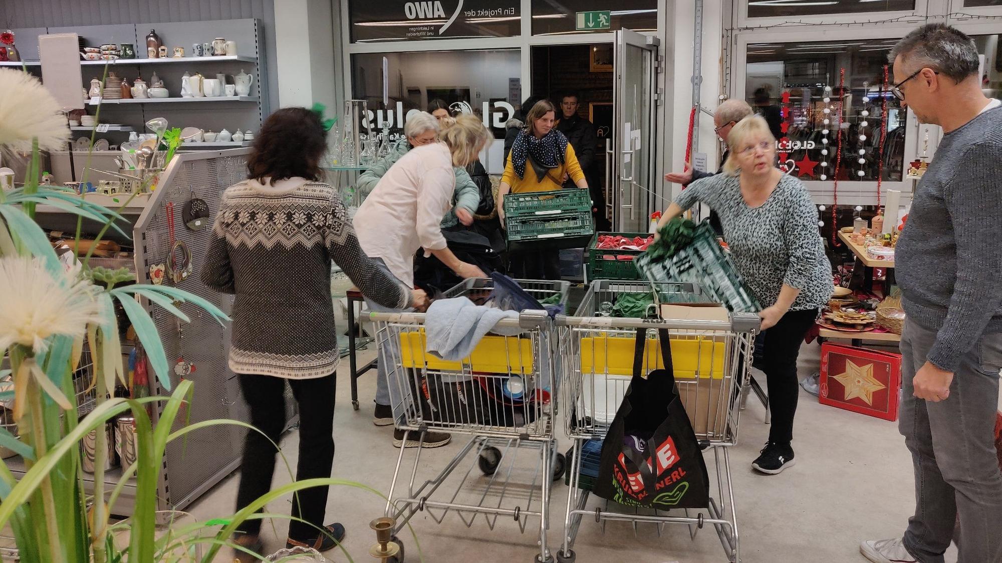 In Kisten und Körben bringen Menschen bei der Warenannahme Spenden vorbei, die direkt gesichtet und sortiert werden.