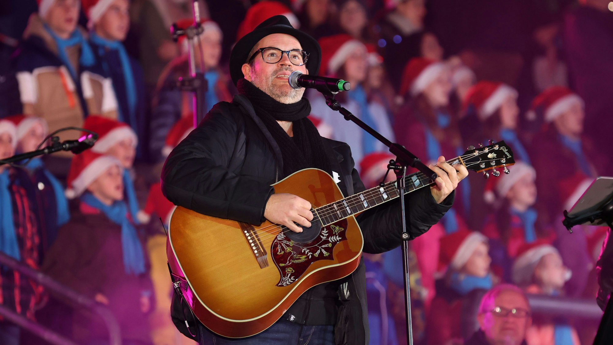 Björn Heuser steht bei „Kölle singt“ in der Lanxess-Aren am Mikro und spielt dazu Gitarre.