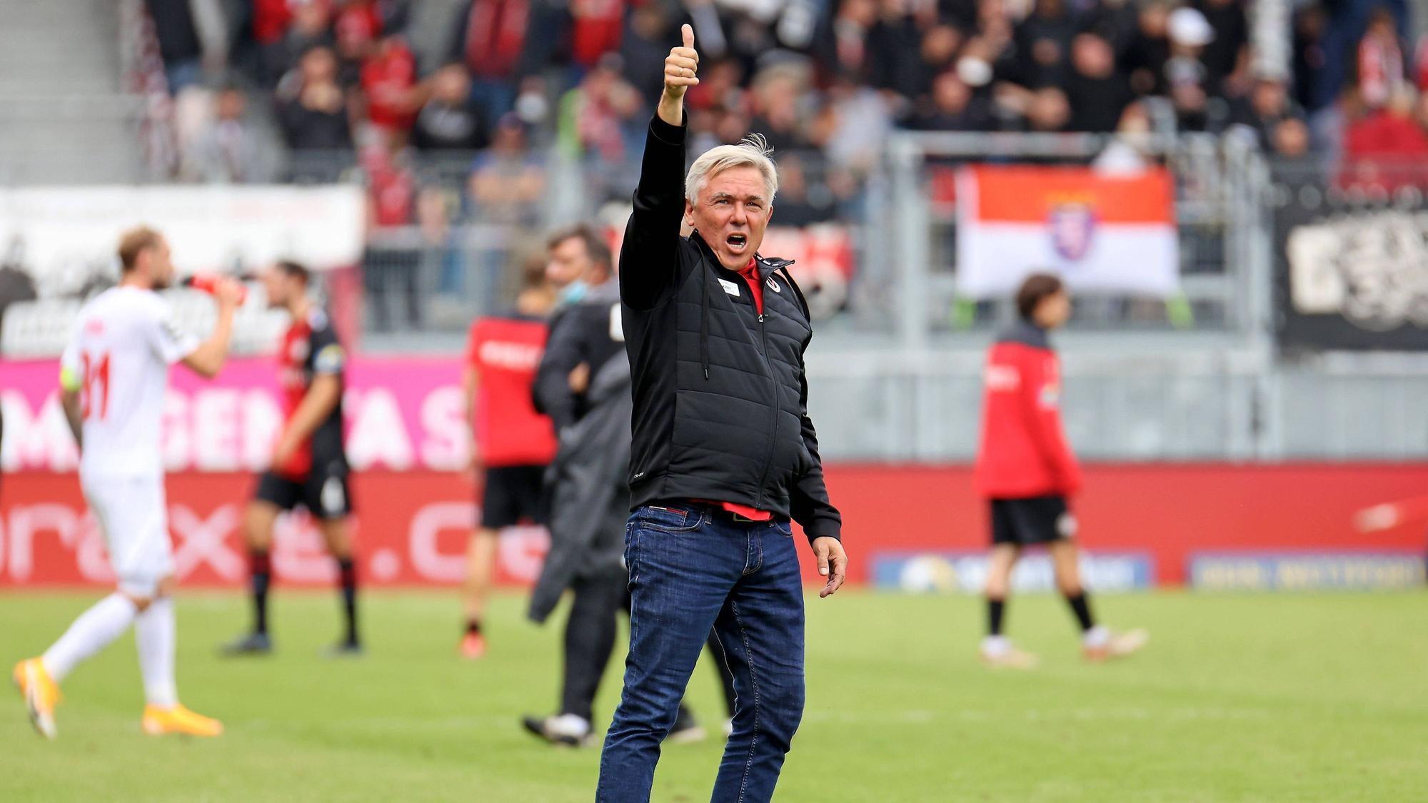 Ein Fußballtrainer reckt nach einem Spiel zufrieden den Daumen in die Höhe.