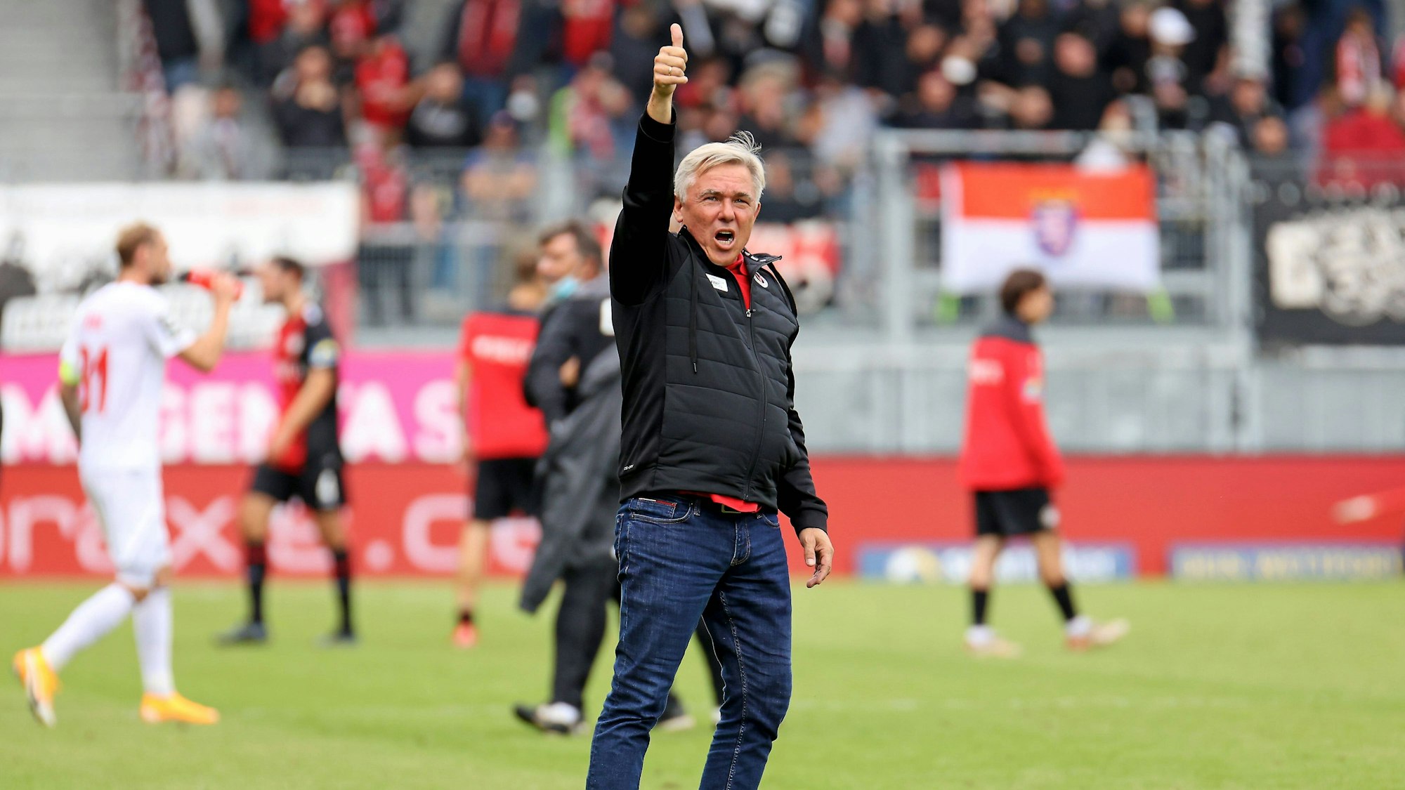 Ein Fußballtrainer reckt nach einem Spiel zufrieden den Daumen in die Höhe.