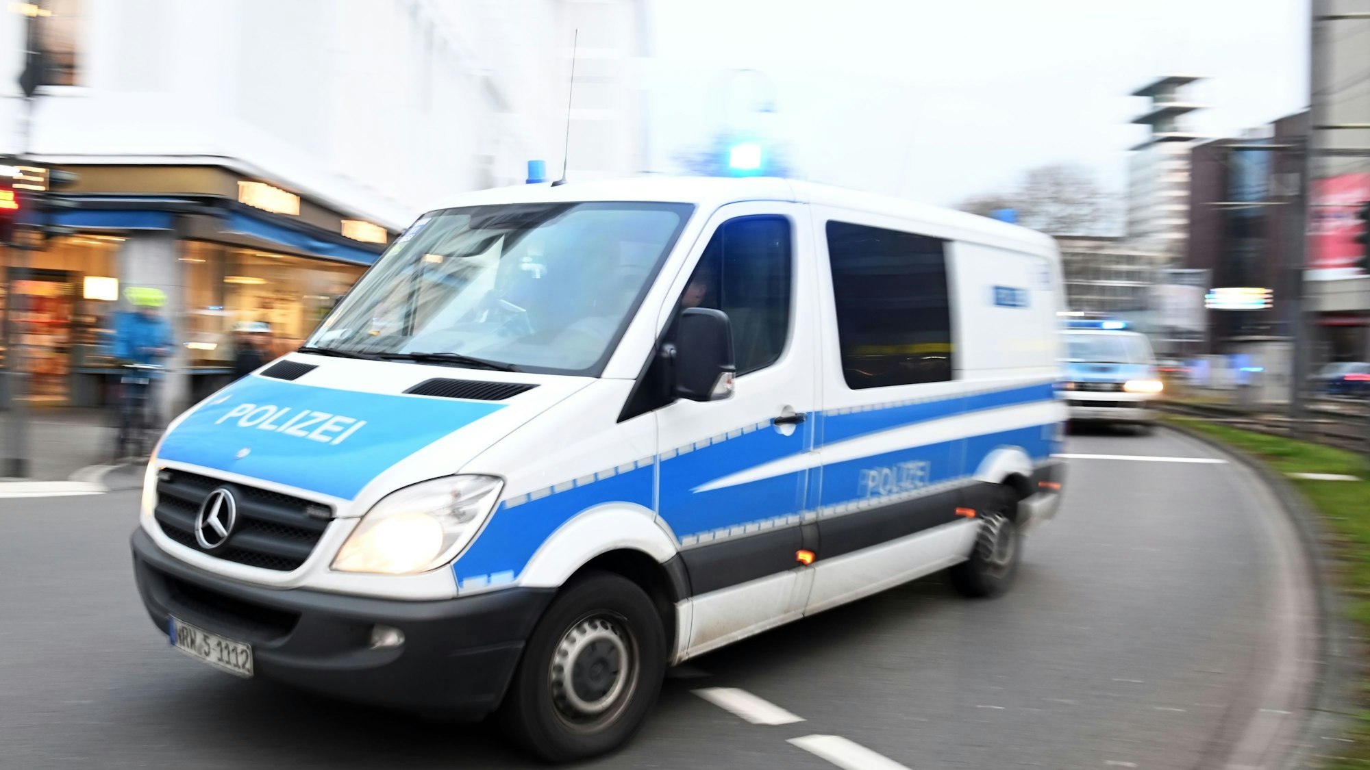 Einsatzfahrzeuge der Polizei fahren auf der Straße.