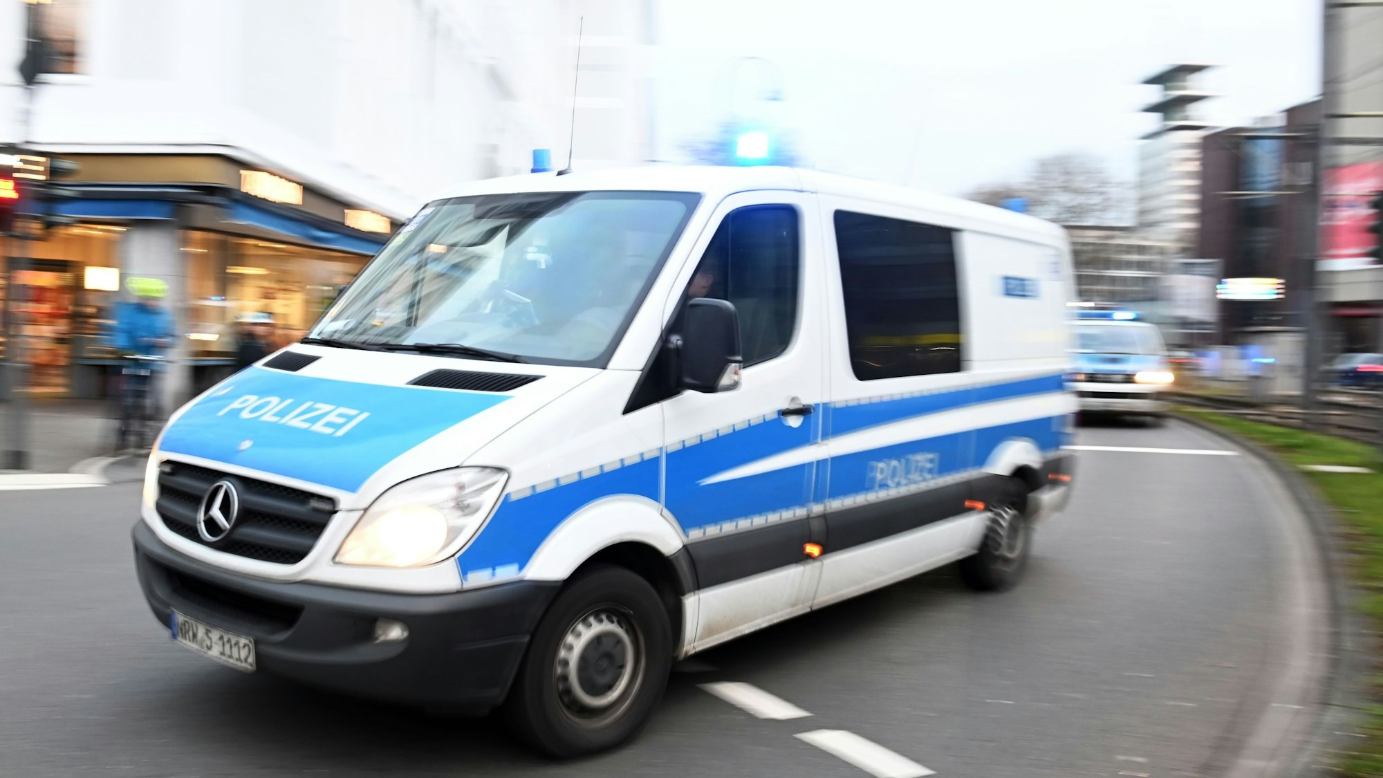 Einsatzfahrzeuge der Polizei fahren auf der Straße.