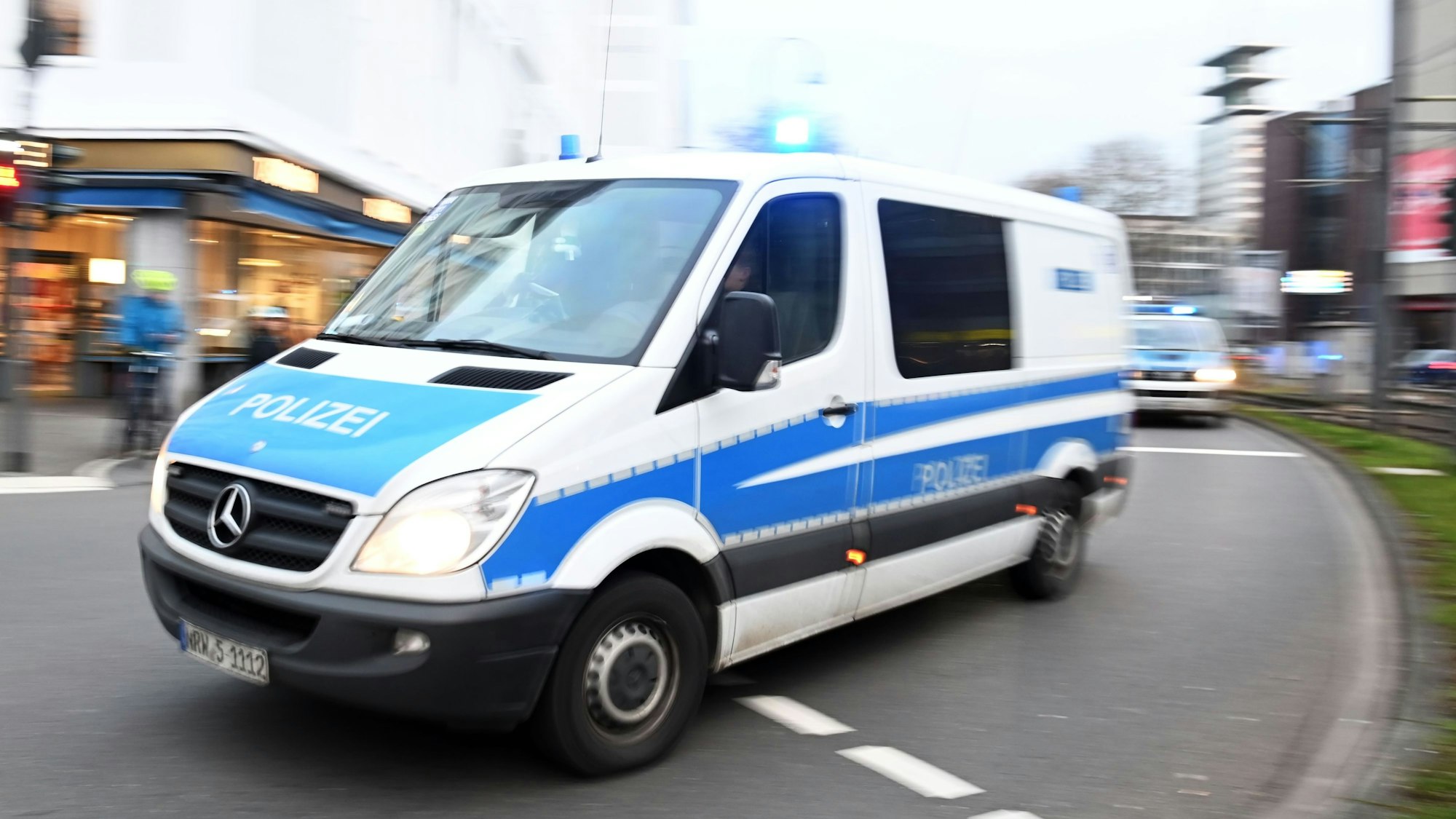 Einsatzfahrzeuge der Polizei fahren auf einer Straße nähe Neumarkt.