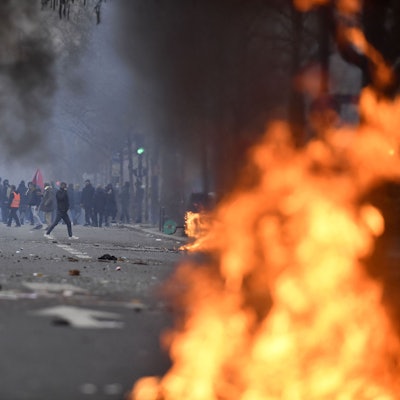 Protestierende stehen hinter Flammen.