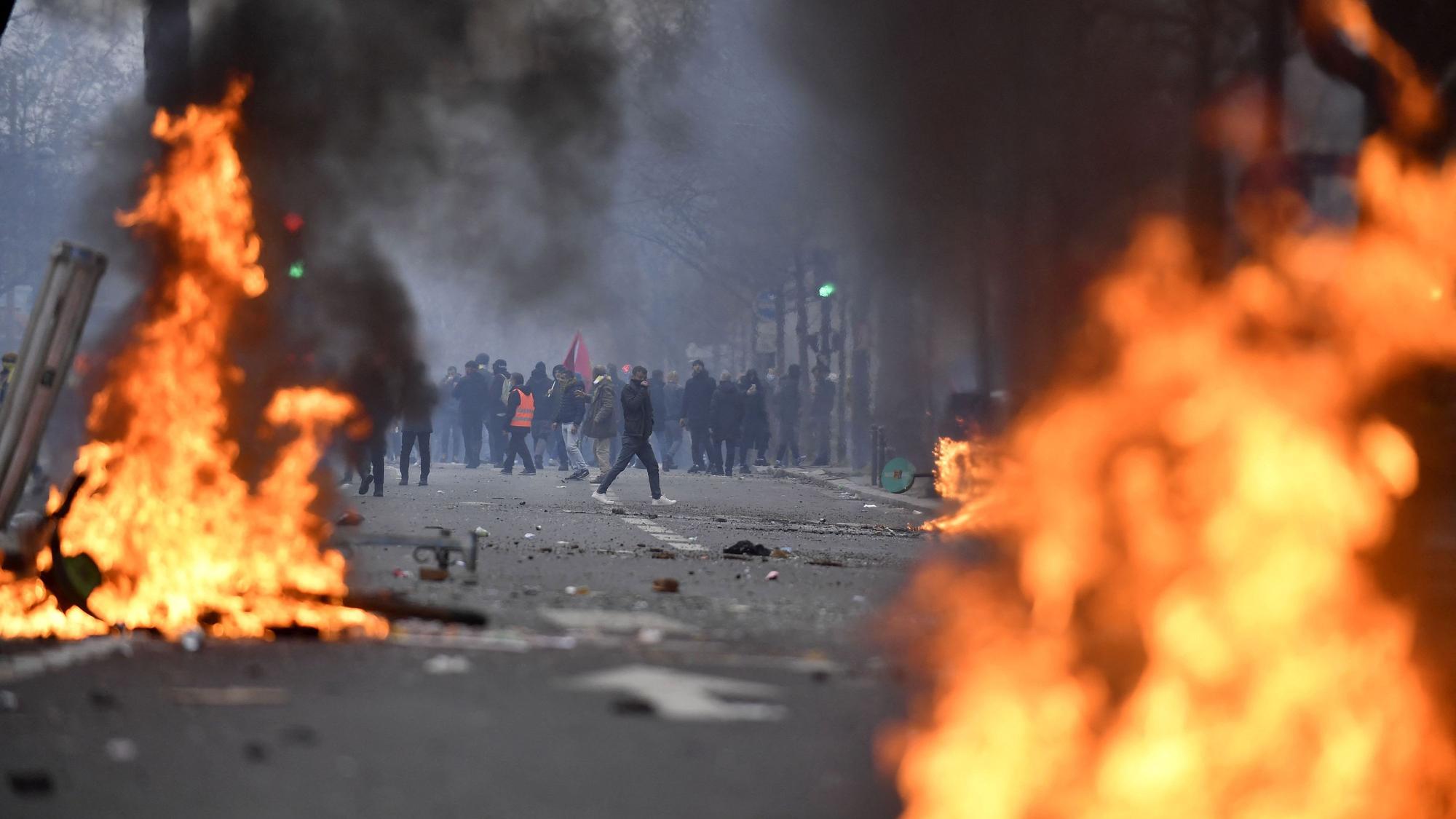 Protestierende stehen hinter Flammen.