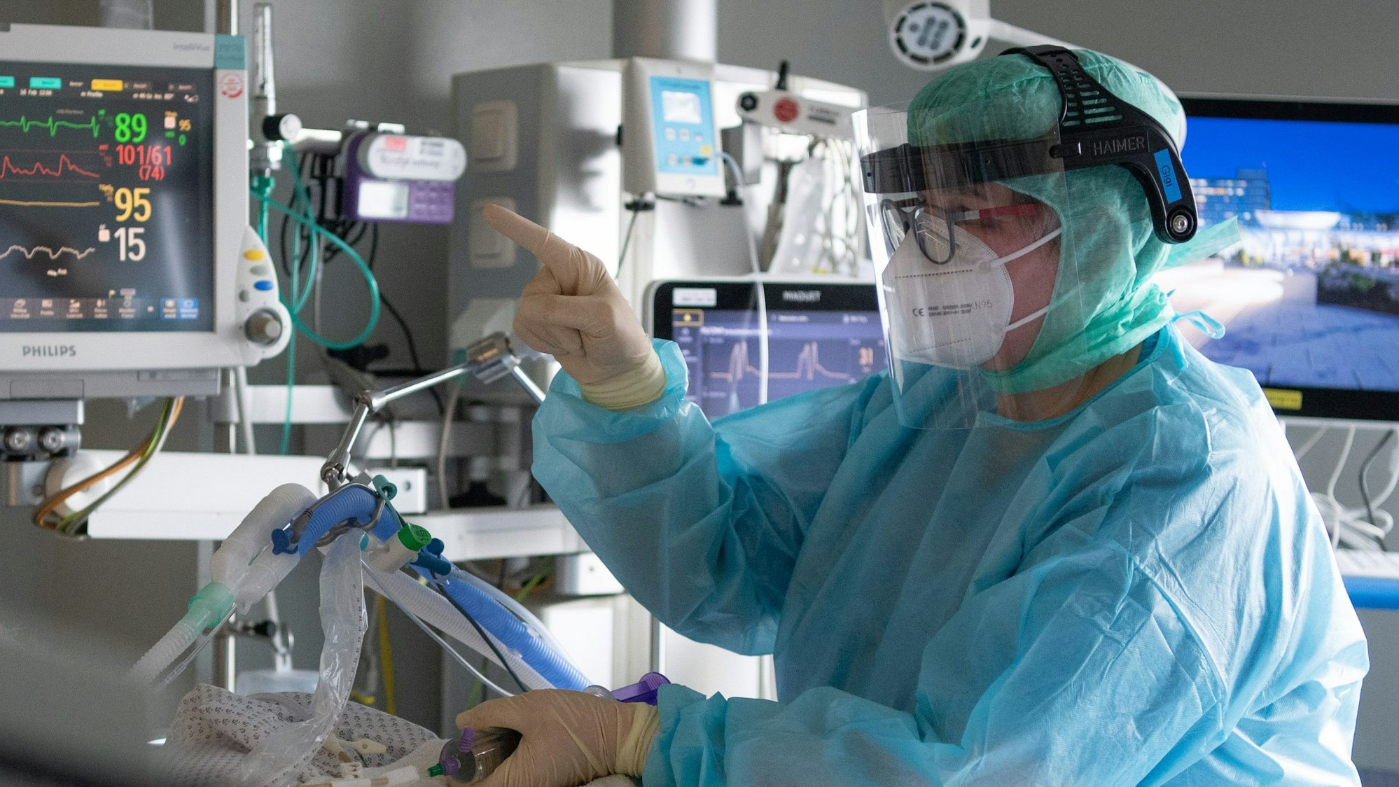 Eine Intensiv-Pflegerin versorgt einen schwer an Corona erkrankten Patienten auf der Intensivstation des Klinikums in Fulda.