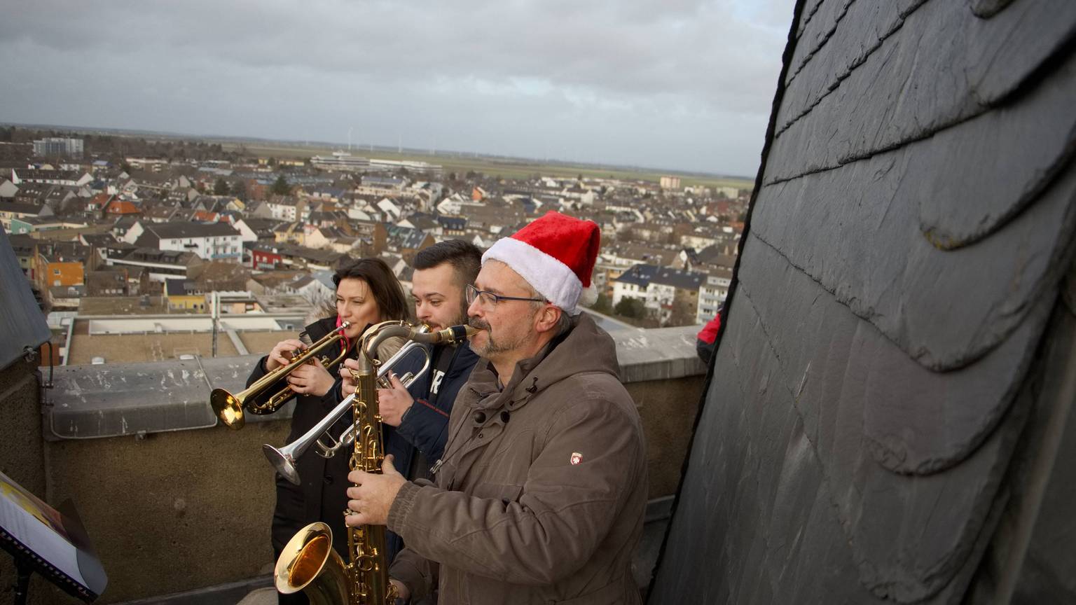 Lea Klose, Bastian Guthausen und Markus Tews spielen auf dem Turm der Herz-Jesu-Kirche Euskirchen Weihnachtslieder.