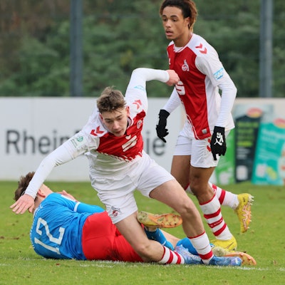 Ein Fußballspieler strauchelt nach einem Zweikampf.