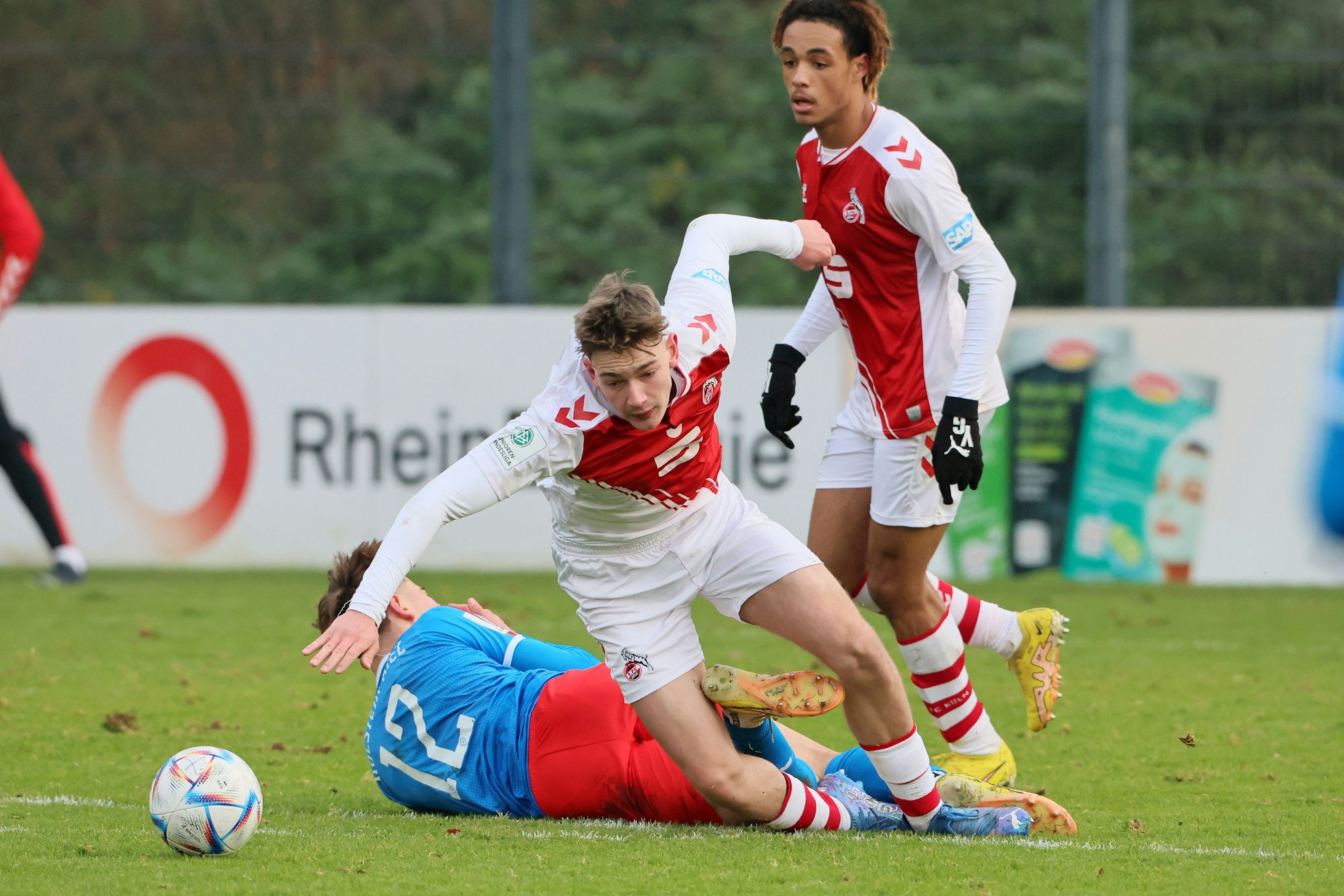 Ein Fußballspieler strauchelt nach einem Zweikampf.