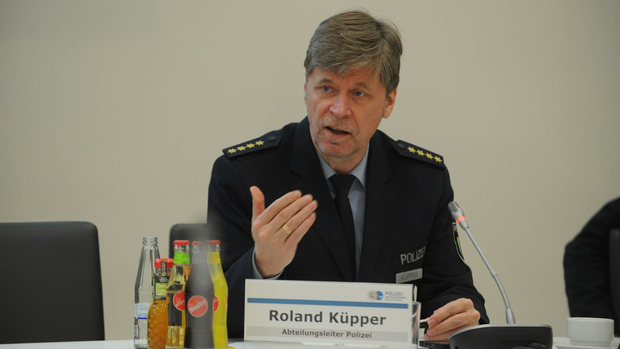 Roland Küpper spricht auf einer Konferenz in ein Mikrofon.
