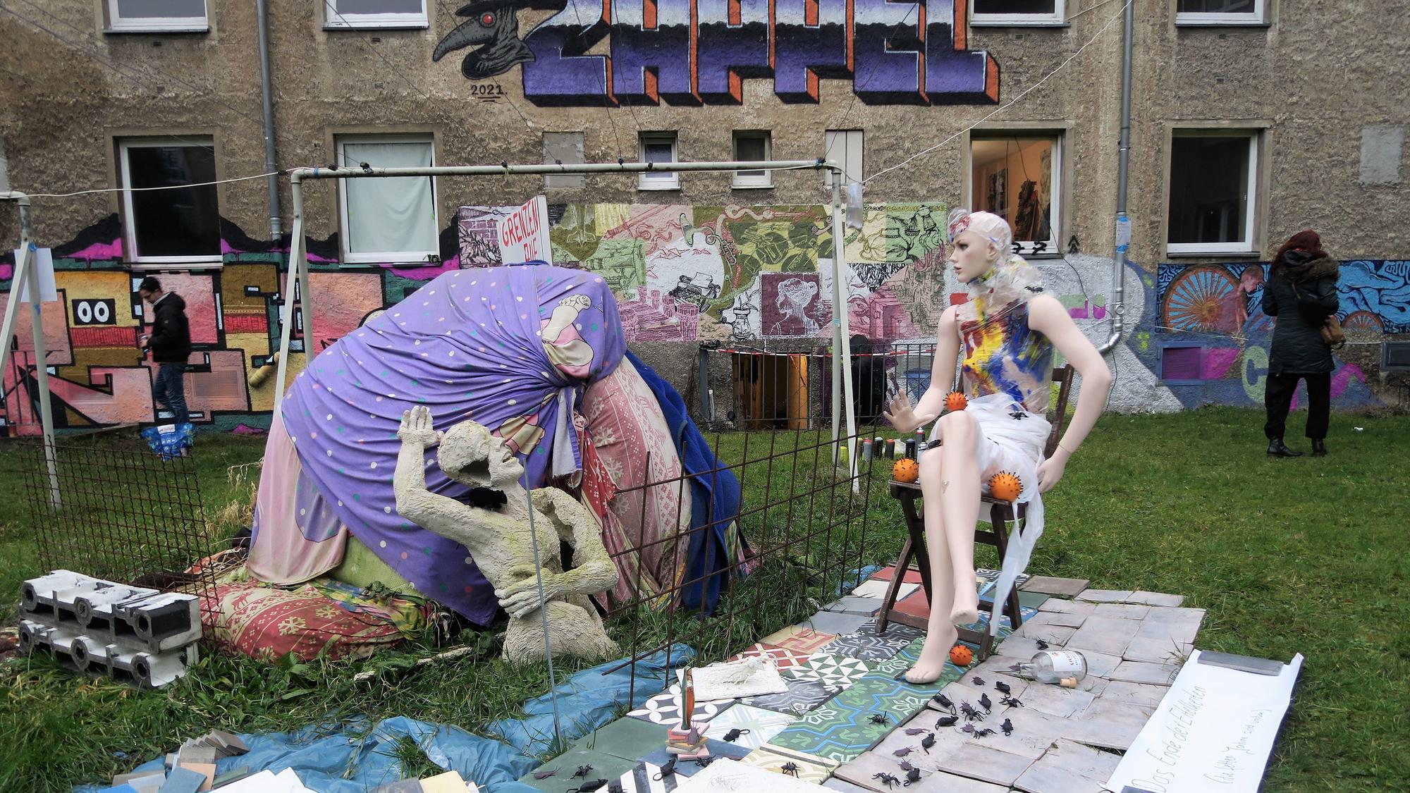 Die Skulptur "Grenzen auf" von Rolf Hartung steht im Innenhof des Wohnquatiers auf einer grünen Wiese.