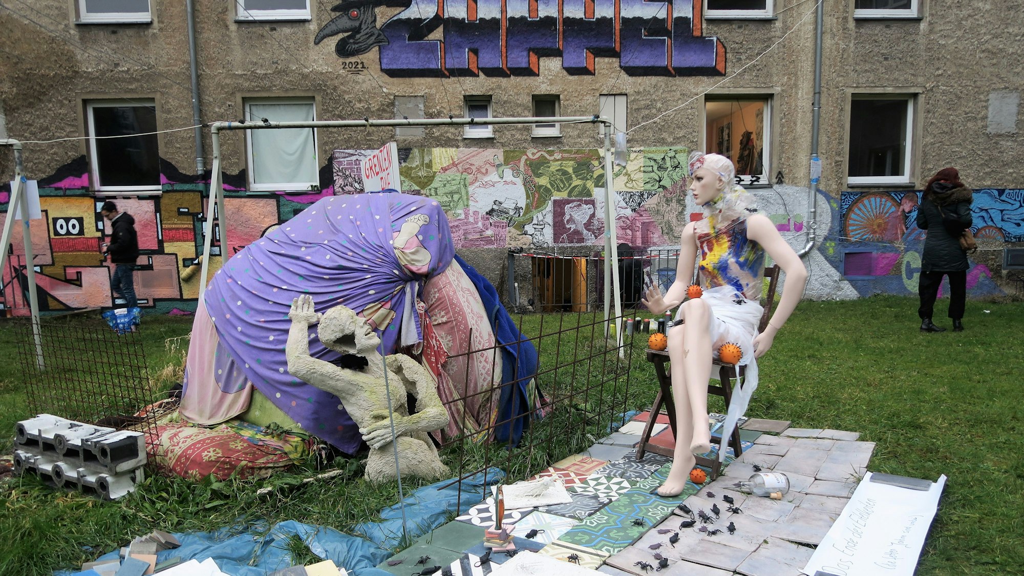 Die Skulptur "Grenzen auf" von Rolf Hartung steht im Innenhof des Wohnquatiers auf einer grünen Wiese.