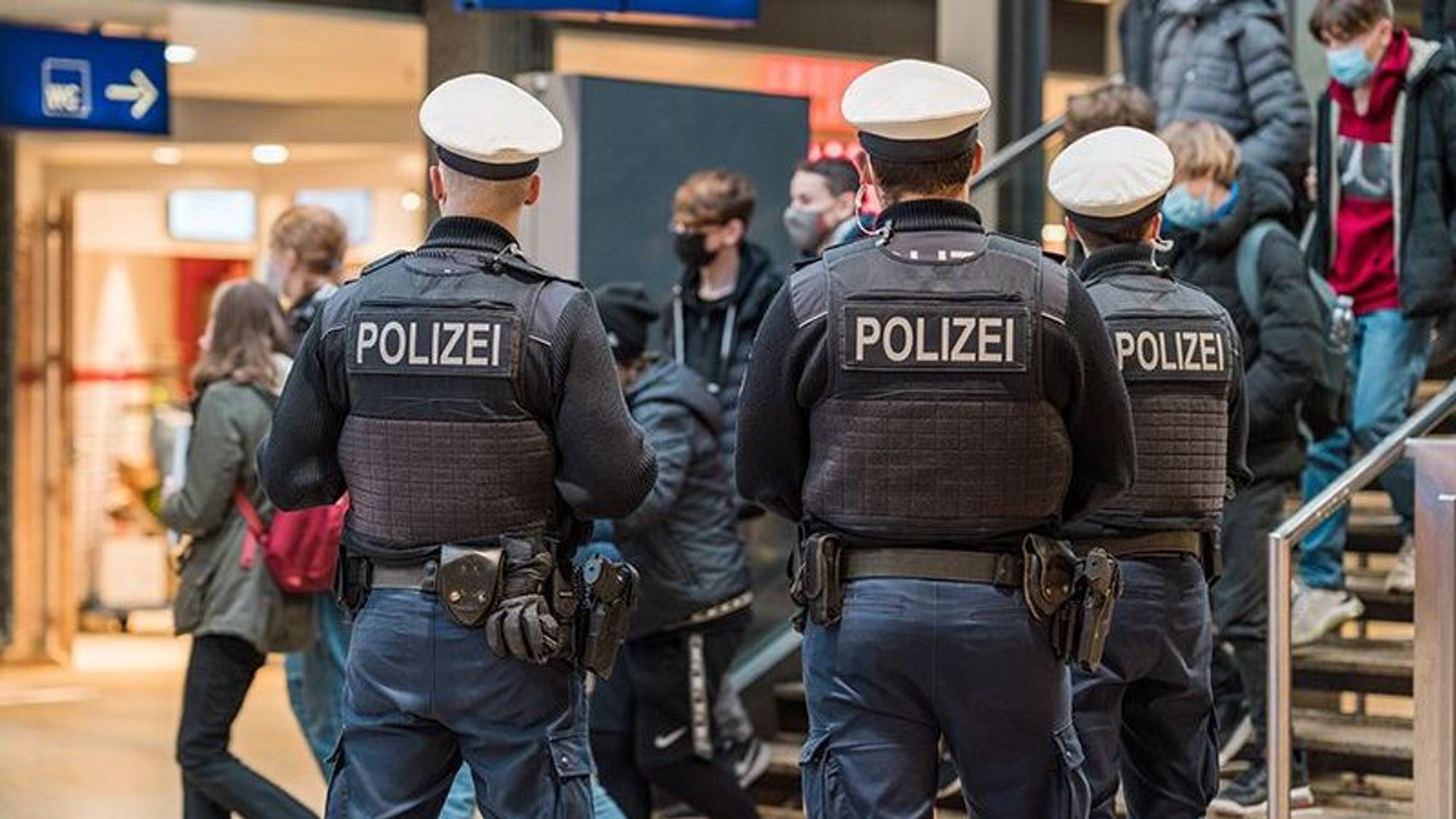 Drei Polizisten stehen vor der Treppe am Hauptbahnhof.