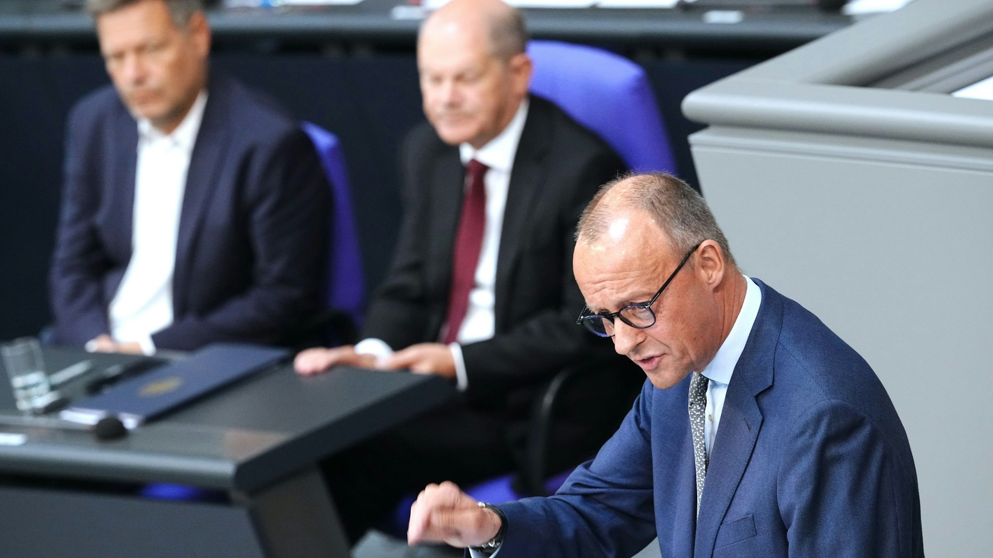 Oppositionsführer Friedrich Merz (CDU, rechts) spricht im Bundestag. im Hintergrund Kanzler Olaf Scholz (SPD, Mitte) und Vizekanzler Robert Habeck (Grüne).