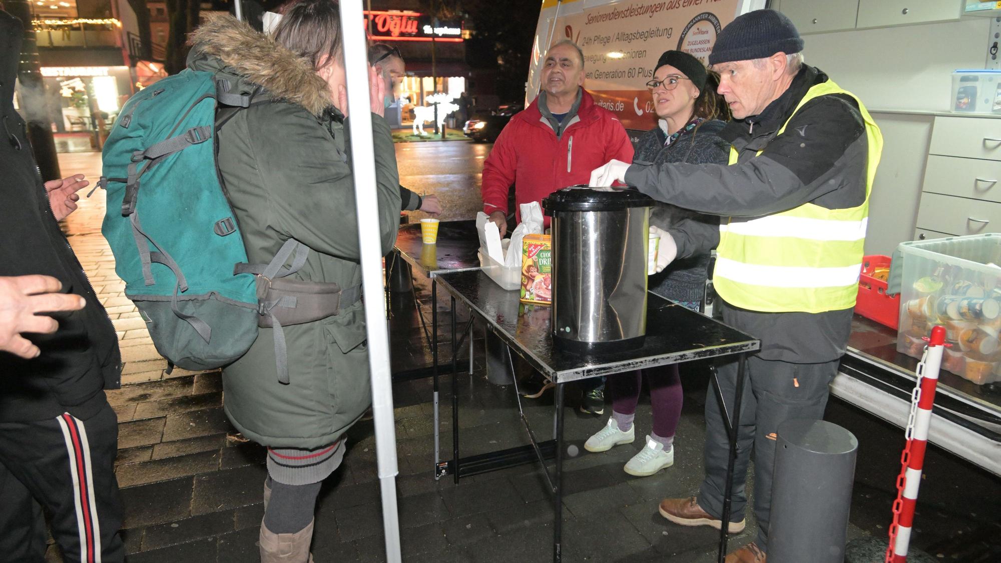 Ali Misini steht vor dem Kältebus und verteilt Essen.