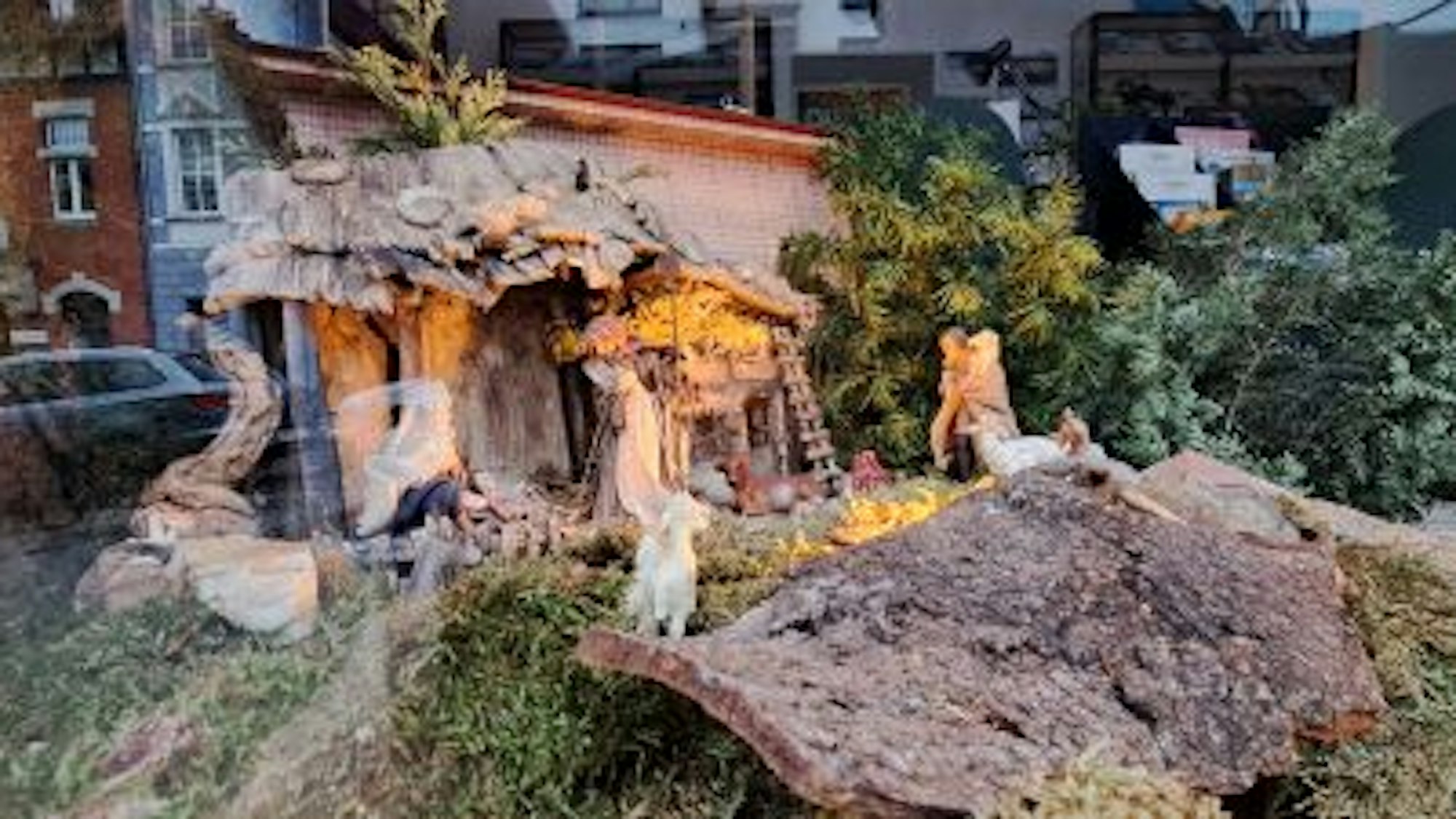 Eine Holzkrippe steht auf einer moosartigen Fläche.