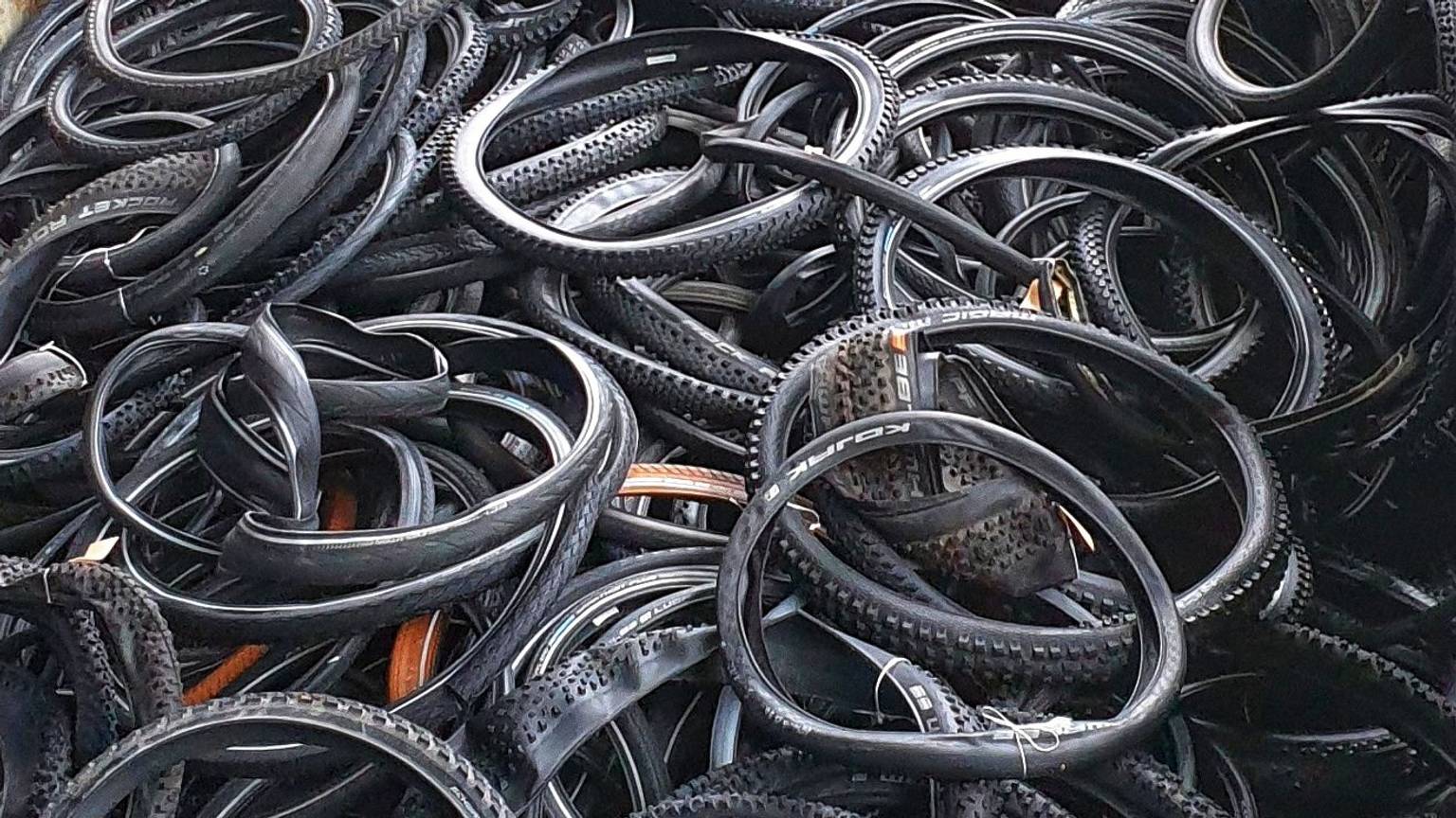 Viele Fahrradreifen liegen auf einem Haufen.