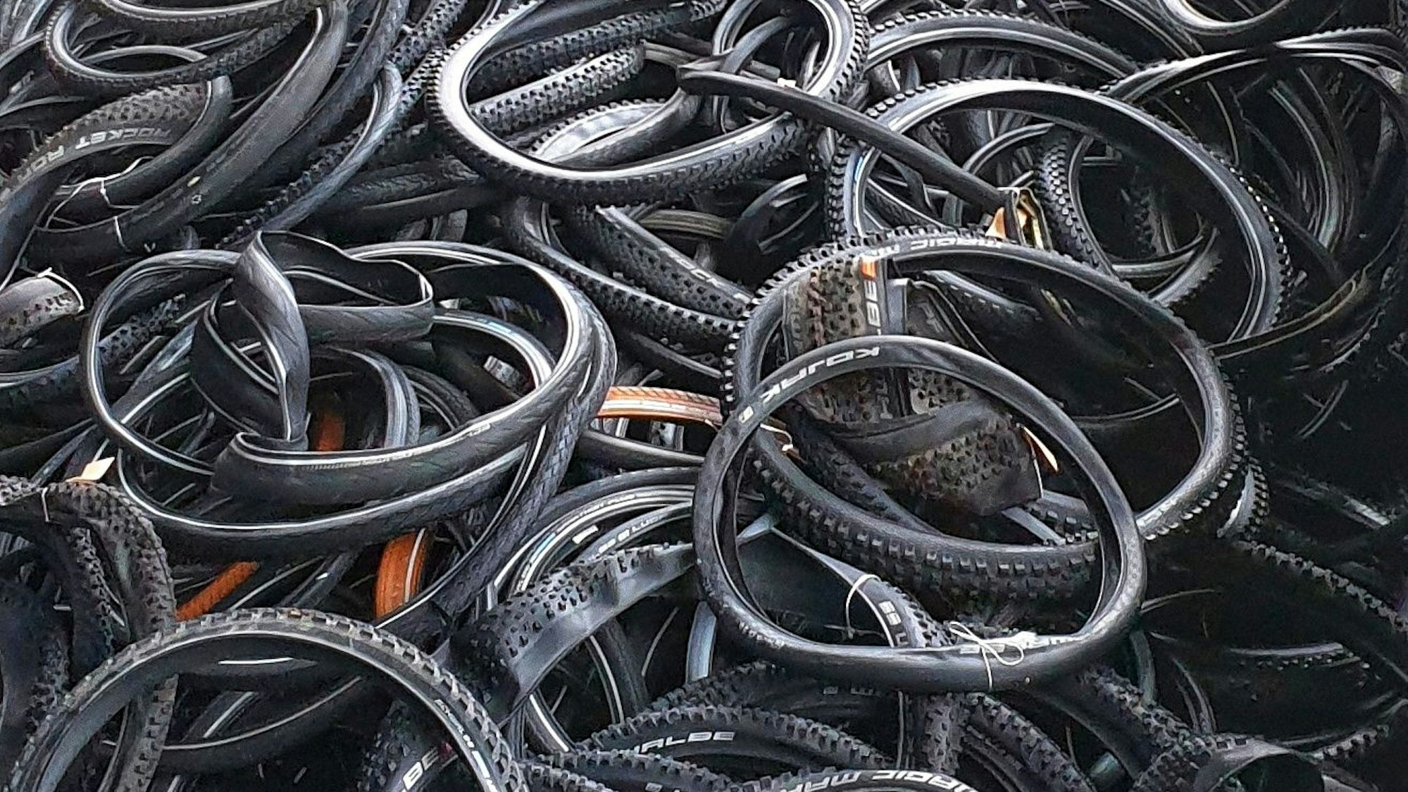 Viele Fahrradreifen liegen auf einem Haufen.