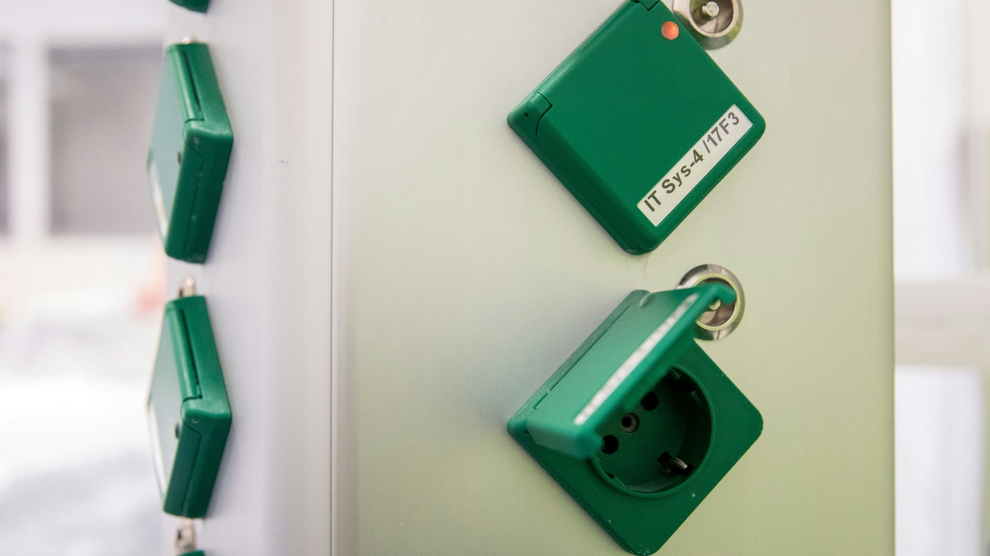 Eine Säule mit grünen Steckerbuchsen ist zu sehen. Sie tragen auf den Abdeckungen eine Kennung. Grün heißt: Auch bei Blackout vom Notstromaggregat versorgt.