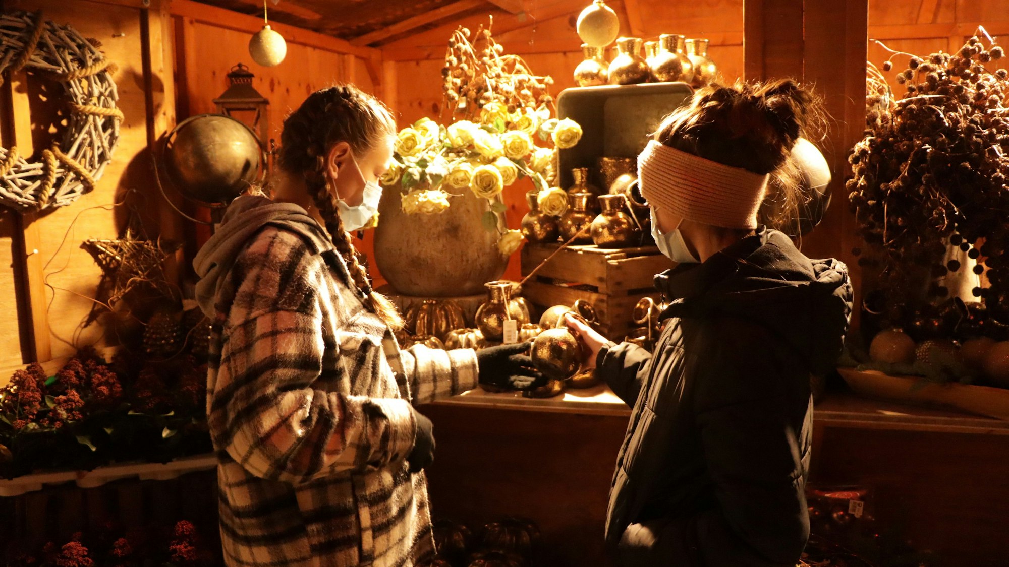 Zwei Kinder stehen an einem weihnachtlichen Stand auf dem Gertrudenhof.