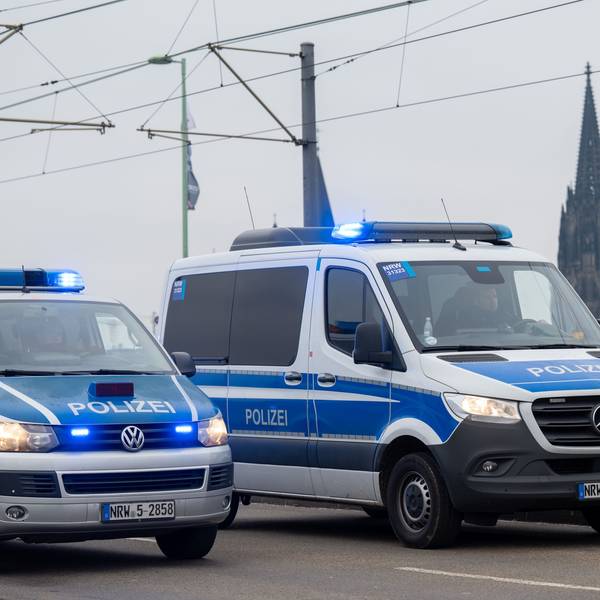 Zu sehen sind zwei Fahrzeuge der Polizei auf der Deutzer Brücke in Köln. Im Hintergrund ist der Kölner Dom zu sehen.