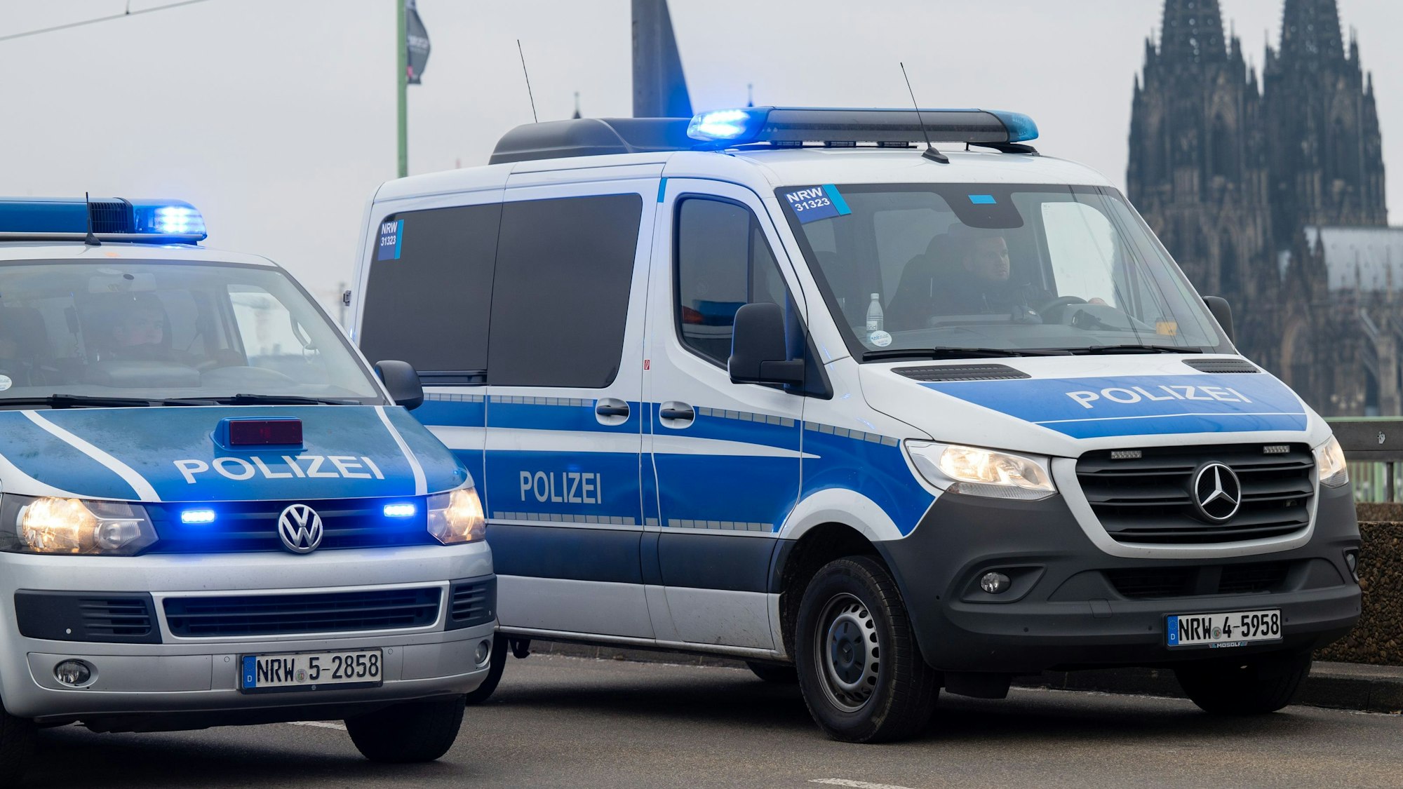 Zwei Polizeiautos vor dem Kölner Dom.