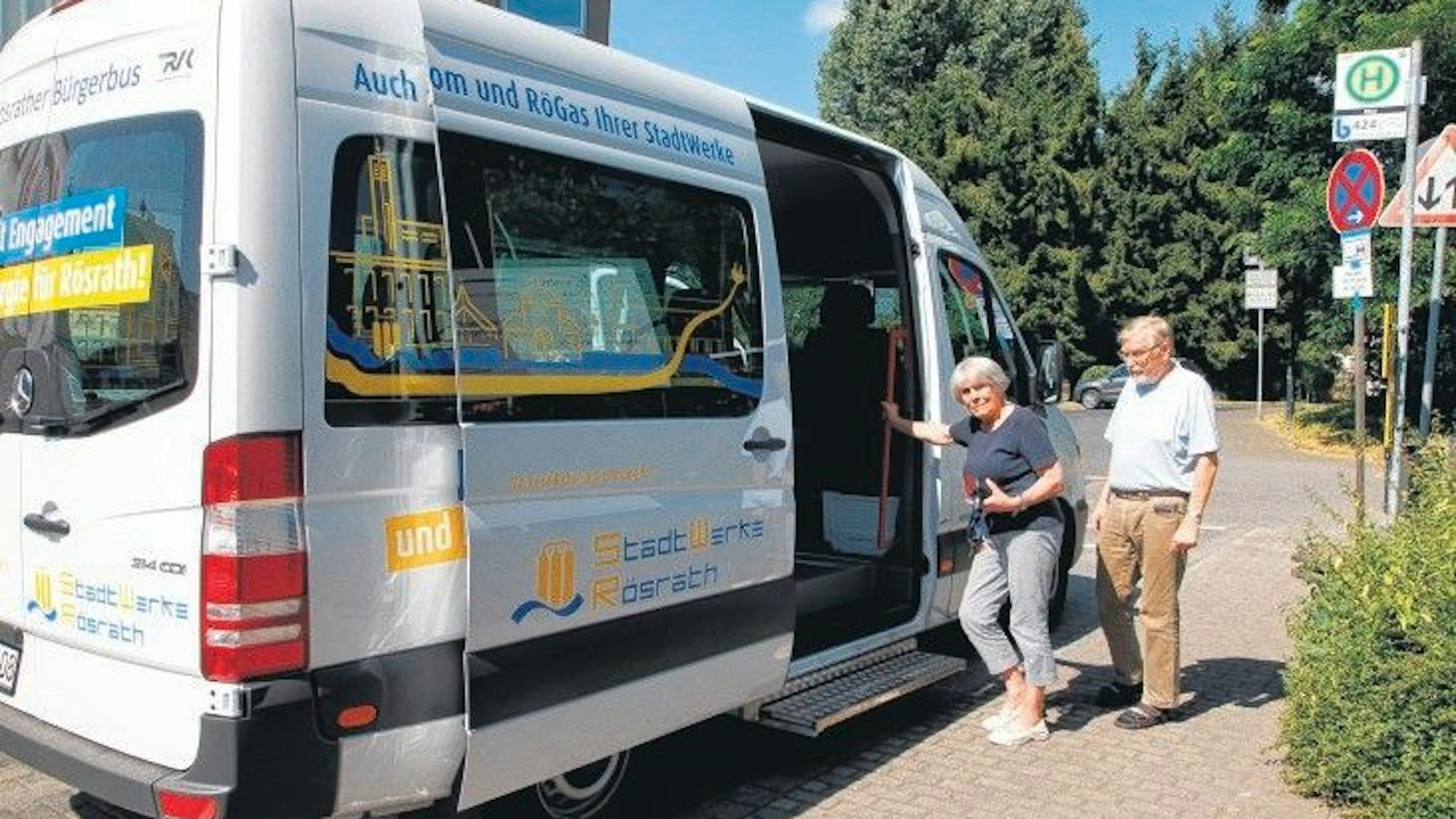 Eine Frau und ein Mann wollen in den Rösrather Bürgerbus einsteigen.