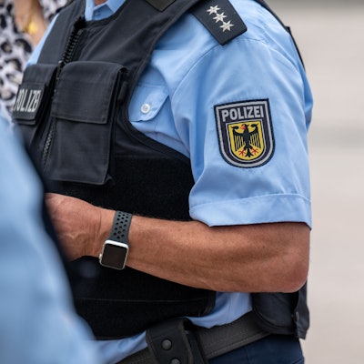 Zu sehen ist ein Bundespolizist in Uniform. Das Emblem der Bundespolizei trägt das Bild des Bundesadlers.